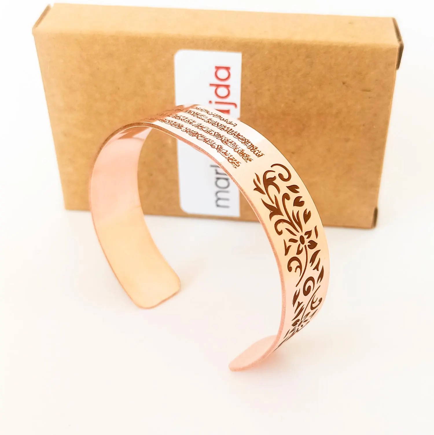 Boho-style Ayatul Kursi jewelry in copper for spiritual protection. The bracelet is open and has a smooth, polished finish.