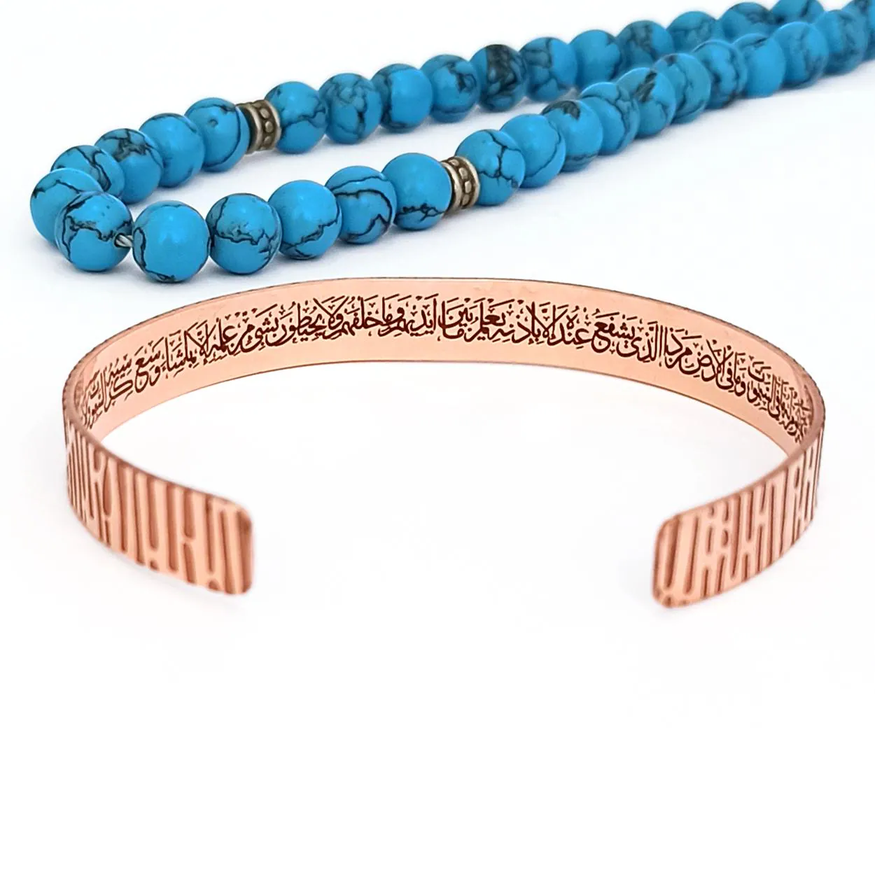 Close up of Arabic calligraphy Ayatul Kursi prayer laser engraved on the inside of a copper bracelet.