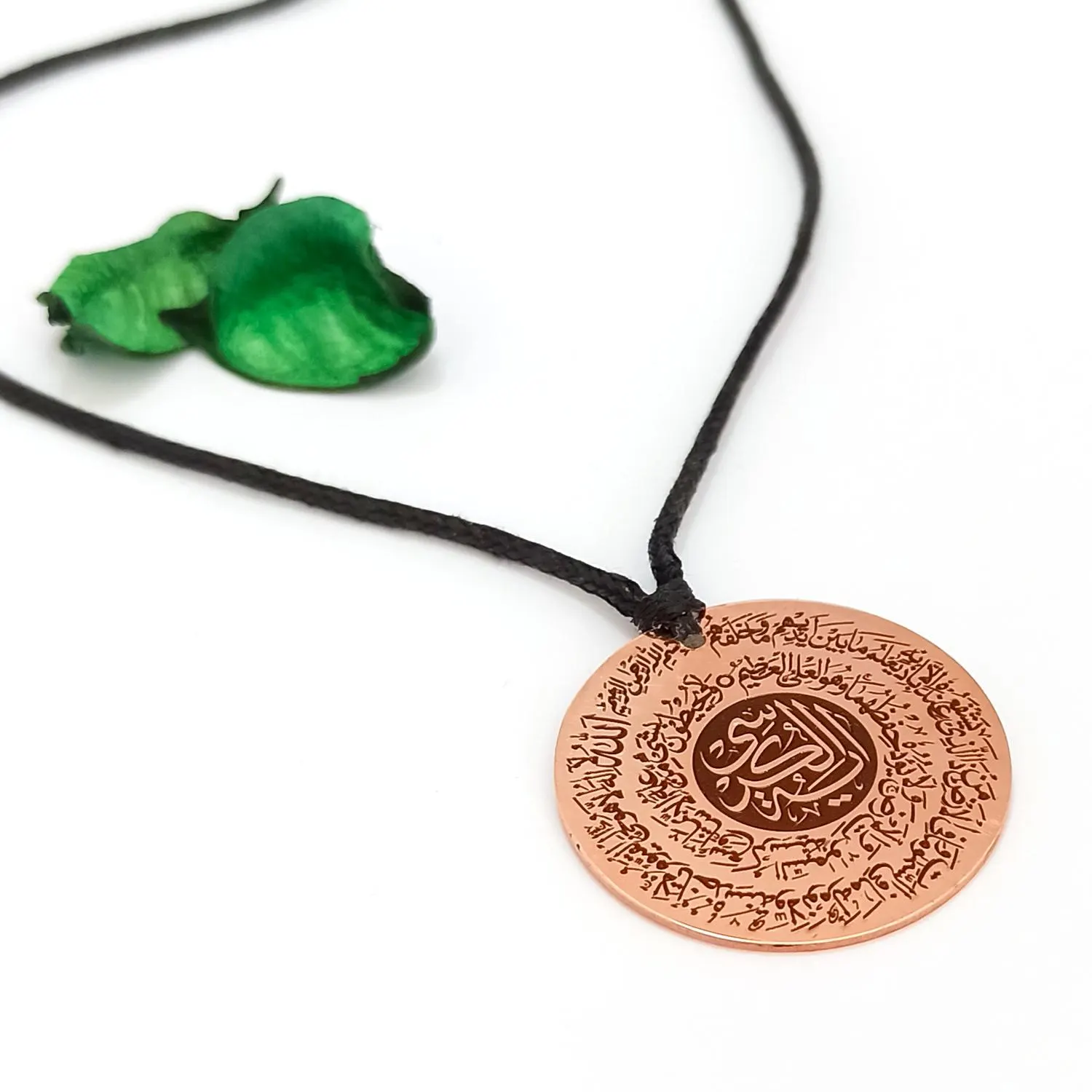 Islamic jewelry for woman. Side view of handcrafted copper pendant showing detailed Islamic engraving.
