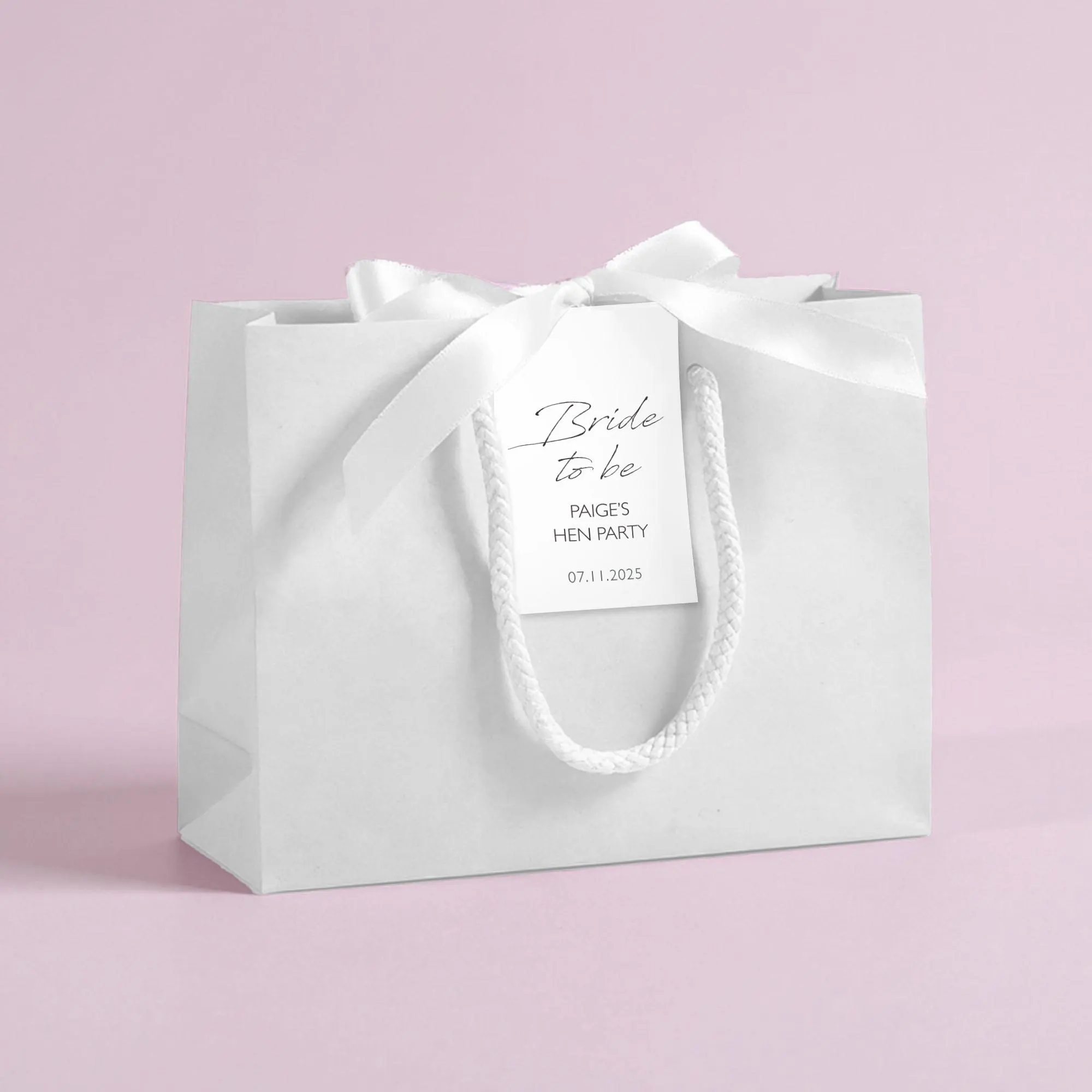 Personalised hen party gift bags with custom tags and ribbons, perfect for adding a special touch to hen do favours. Made from 100% recycled paper with reinforced bases and soft rope handles, these elegant bags can be customised with names, dates, or messages. Ideal for presenting gifts or party favours in style.