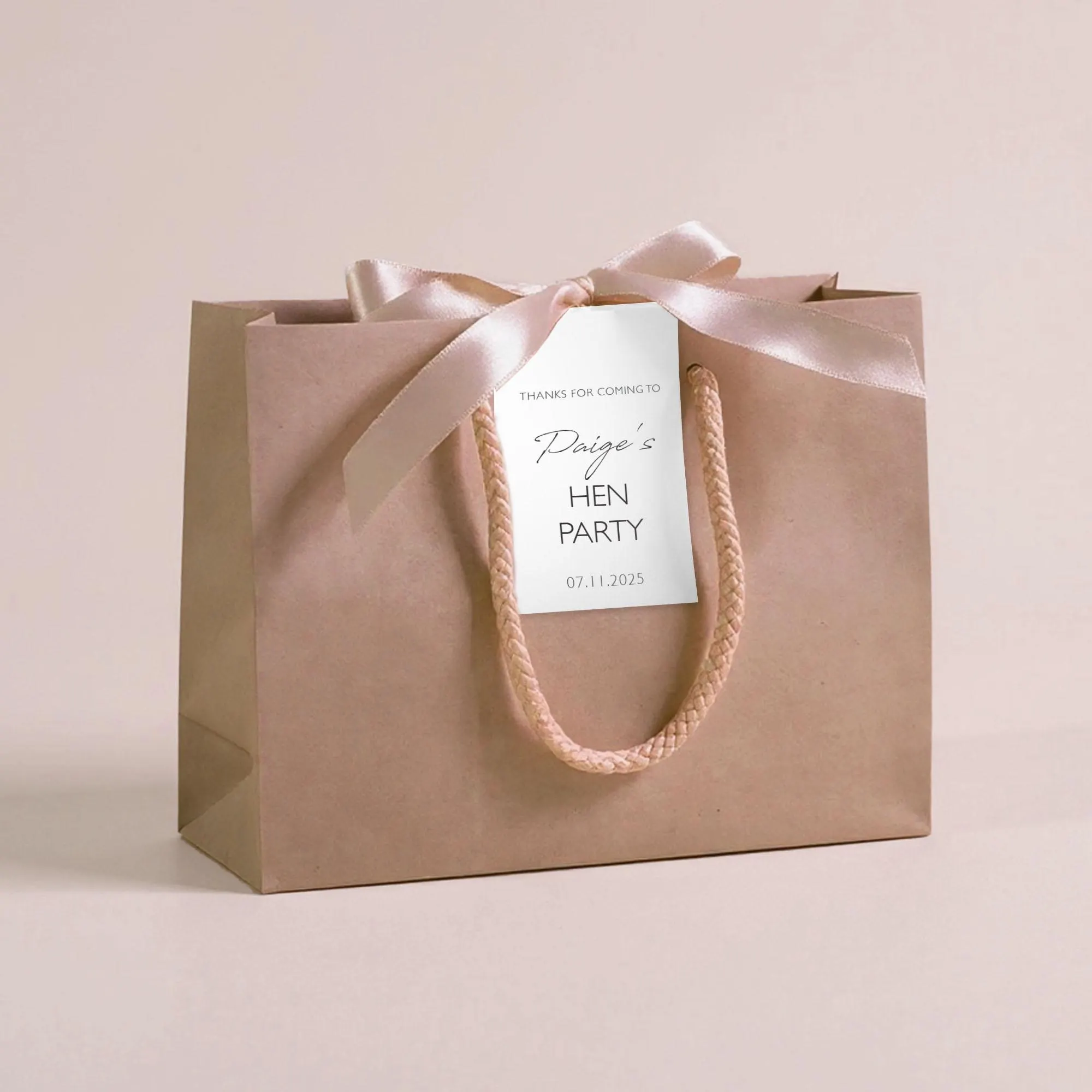 Personalised hen party gift bags with custom tags and ribbons, perfect for adding a special touch to hen do favours. Made from 100% recycled paper with reinforced bases and soft rope handles, these elegant bags can be customised with names, dates, or messages. Ideal for presenting gifts or party favours in style.
