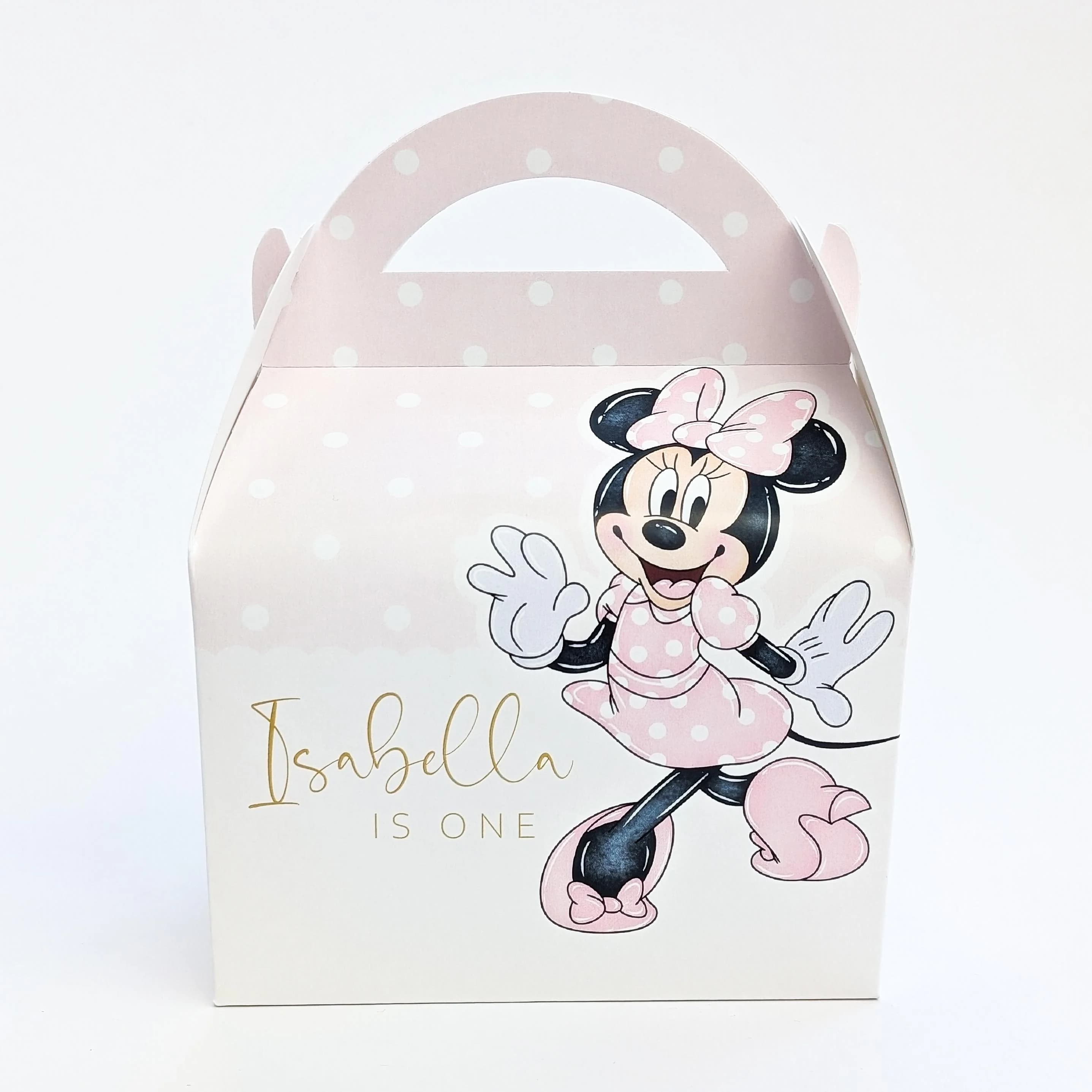 May include: A pink party favour box with a handle, decorated with a Minnie Mouse illustration in a pink polka-dot dress and bow. The box has the text "Isabella is One" in gold script, ideal for a children's birthday party.