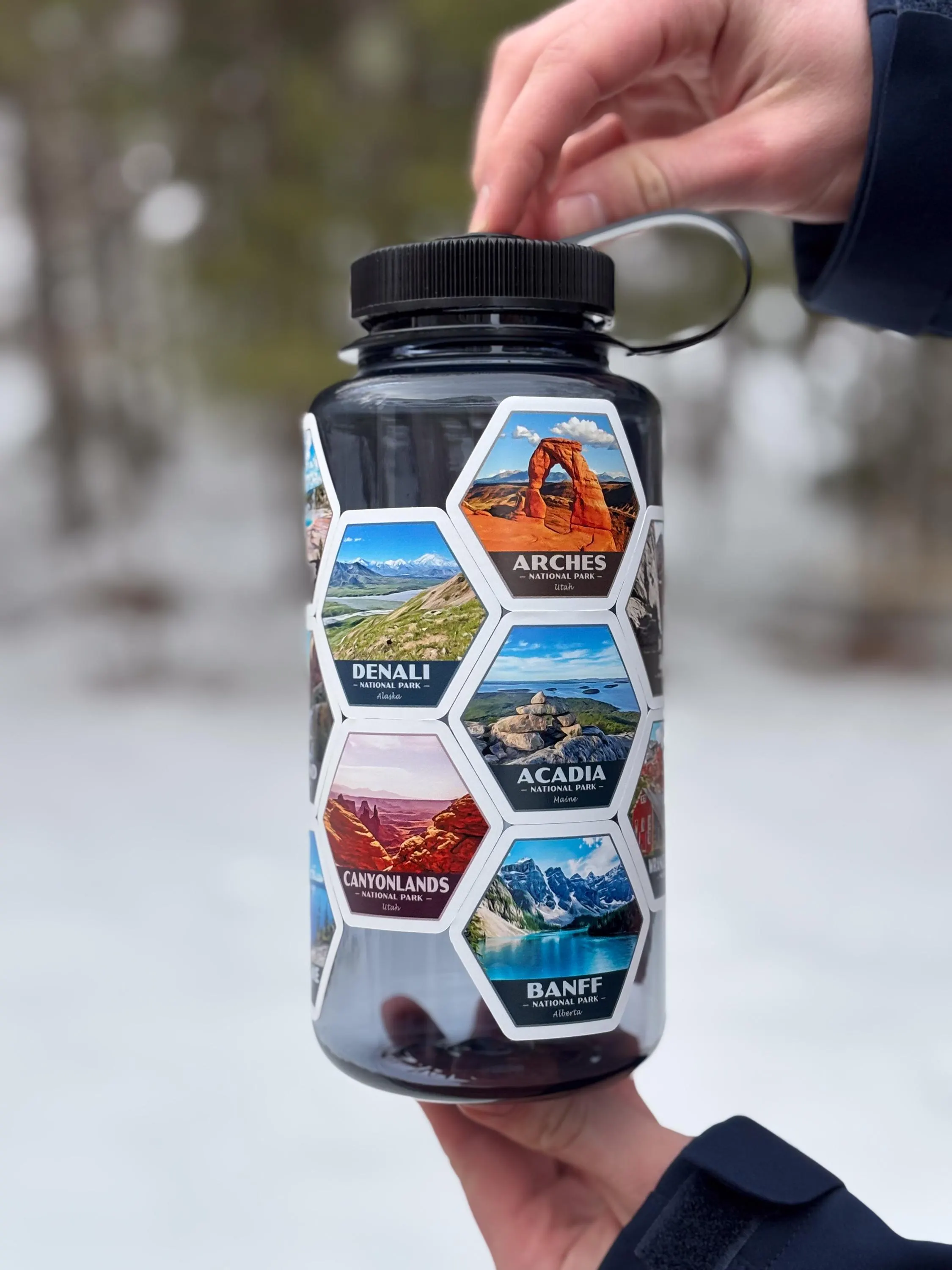 a person holding a water bottle with pictures on it