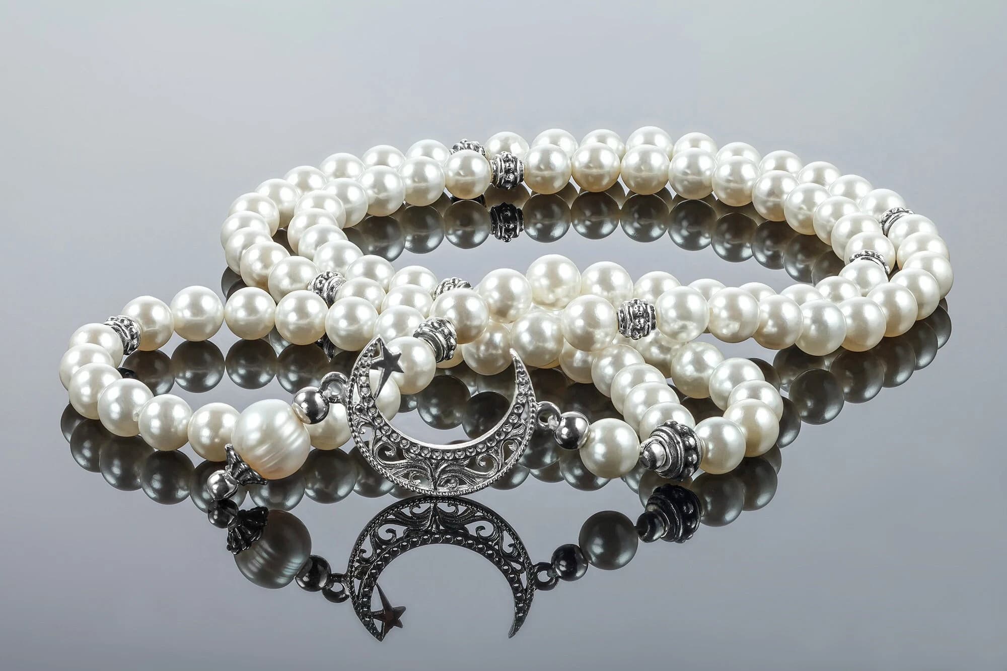 Islamic prayer beads (tasbih) made with elegant white pearl-like beads and silver-toned spacers, featuring a decorative crescent moon and star charm. Perfect for daily prayers, Ramadan, or Eid celebrations. Can be used as a meaningful gift for Muslim women or men, combining spiritual significance with a stylish design. Smooth beads for comfortable use during dhikr, suitable for personal devotion or as a keepsake. Reflective surface adds an elegant and luxurious presentation.