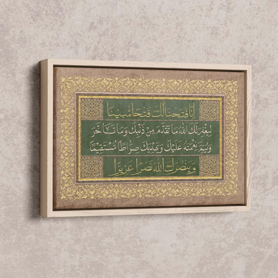 Surah Al-Fath Islamic canvas art in natural wood frame, displaying emerald green background with golden Arabic calligraphy and ornate brown and cream border patterns, hung on beige wall above light brown leather sofa with accent pillows