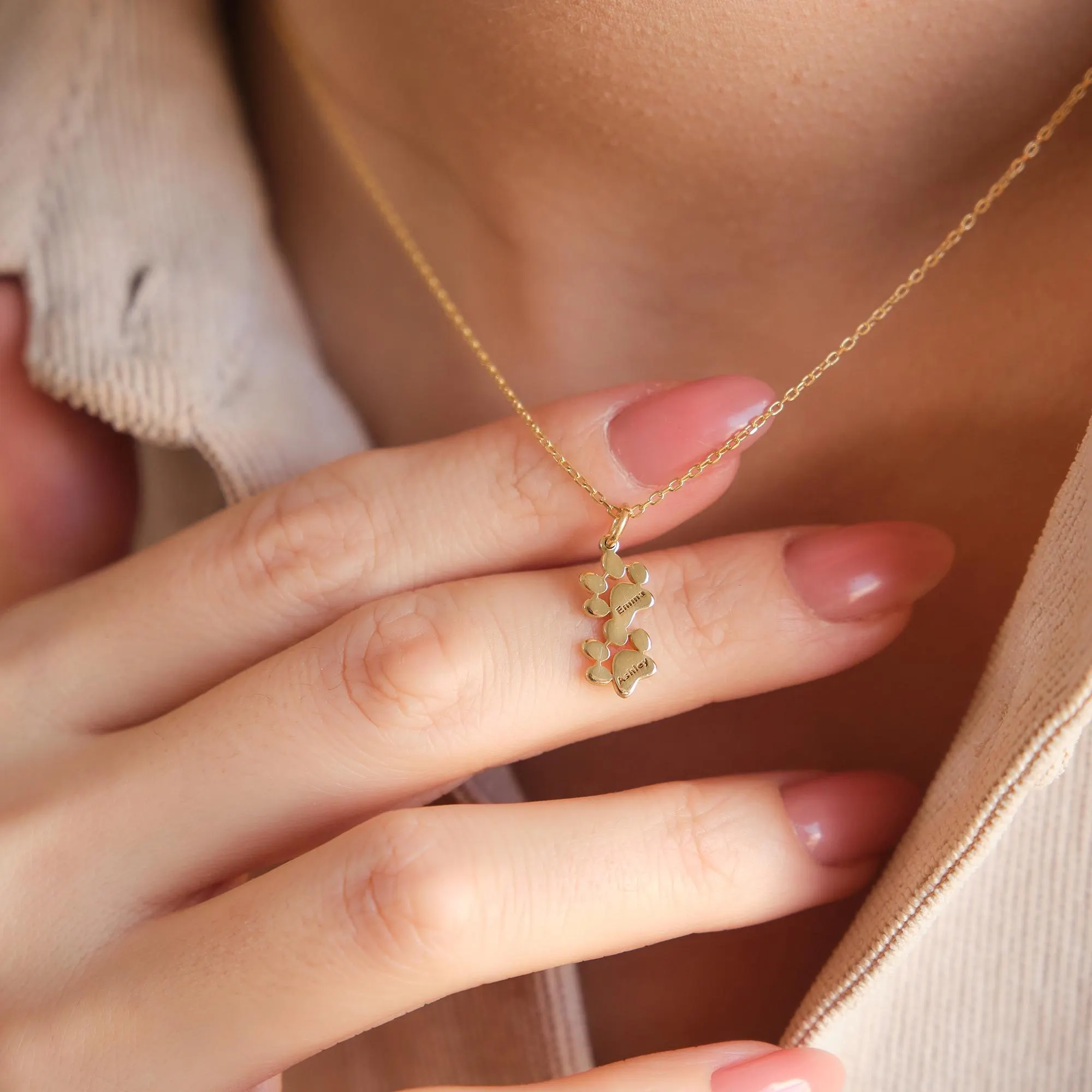 Double paw print gold necklace with two engraved names, custom pet charm.”
