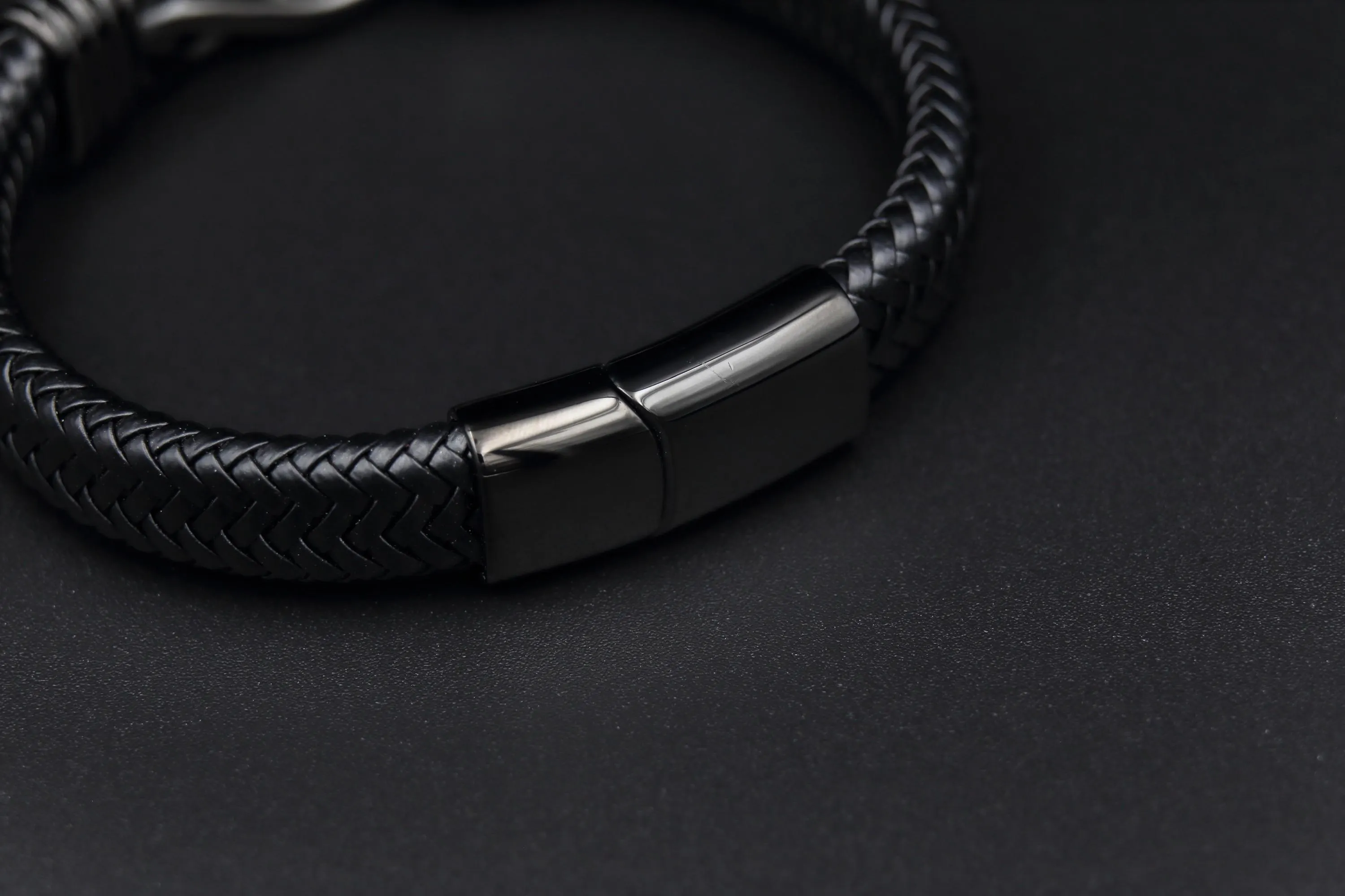 a black leather bracelet with a metal clasp
