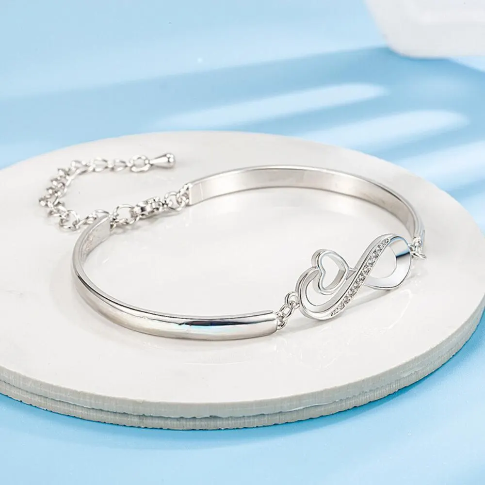 a white plate with a silver bracelet on it
