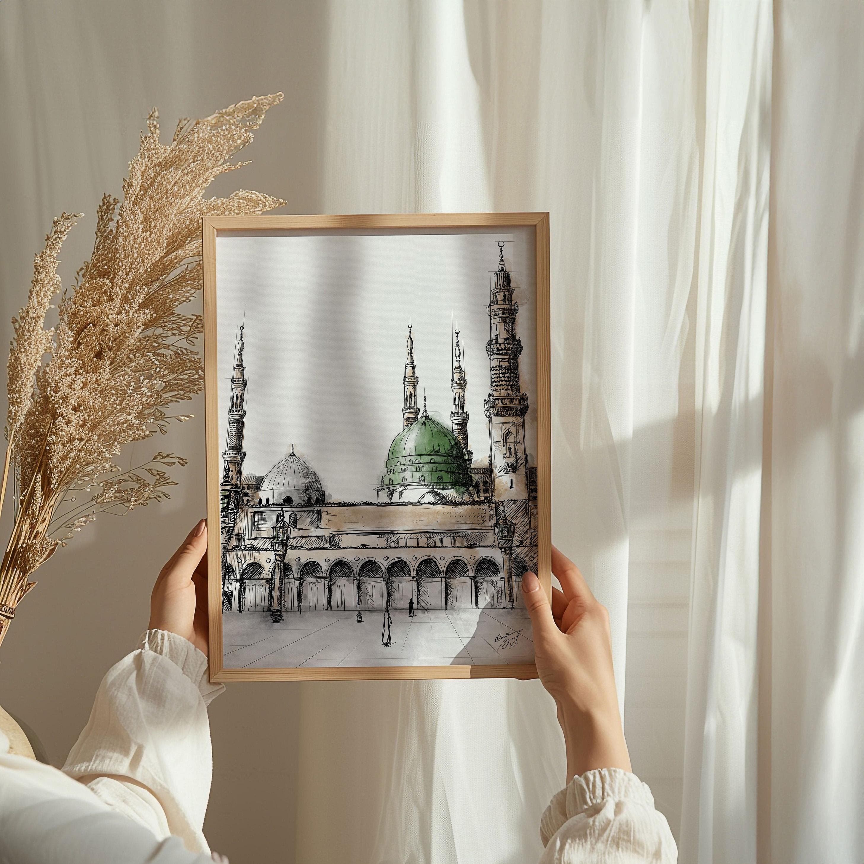 Hands holding frame – Person holding a wooden frame featuring the Green Dome Mosque watercolor sketch, with beige dried flowers and flowing curtains in the background, highlighting the artwork’s spiritual and artistic details.