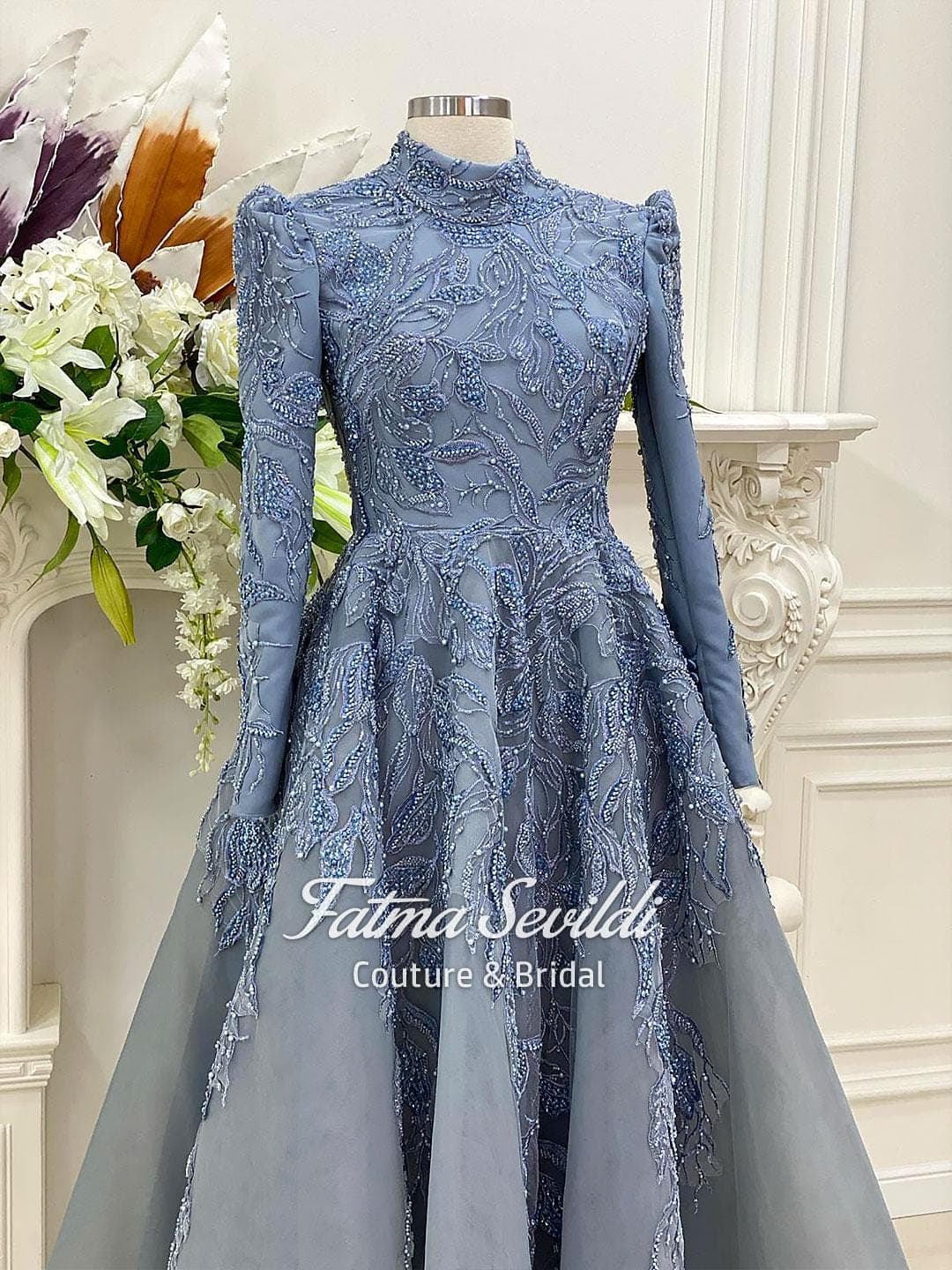 Blue beaded lace hijab evening gown with high neck, long sleeves, and a structured modest ballgown silhouette. Custom made for a refined luxury formal look.