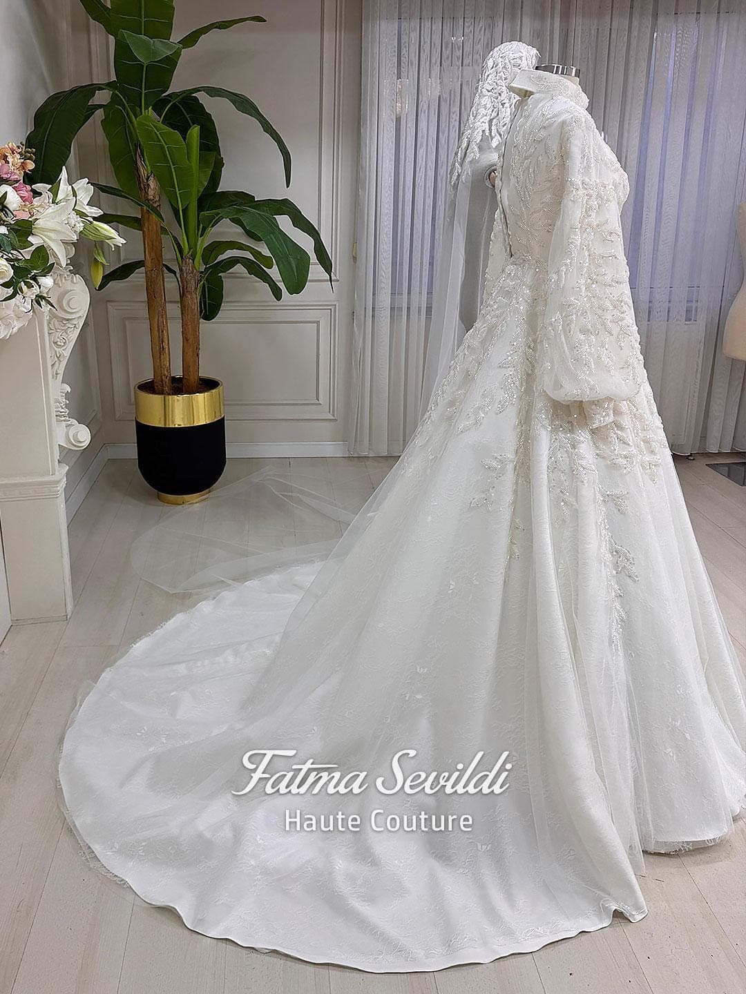 Veiled hijab wedding dress in a couture ballgown silhouette with high neck, long sleeves, and shimmering beaded lace, made to measure.