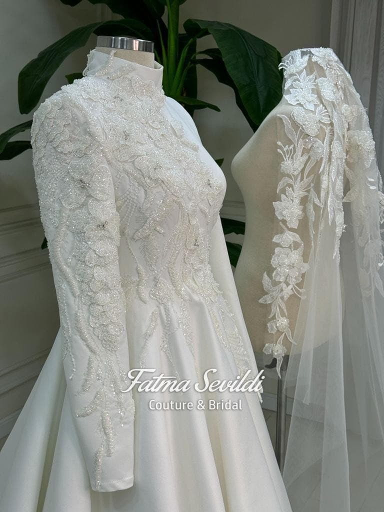 Veiled hijab wedding dress in luminous satin with high neck and long sleeves, custom made with corsetry for a luxury modest ballgown silhouette. Includes a premium lace veil for a complete Muslim bridal set.