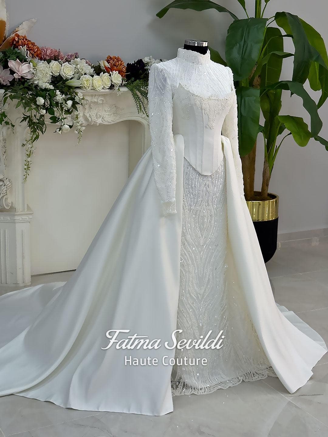 Luxury hijab wedding dress with long sleeves, high neck, beaded lace mermaid silhouette and detachable overskirt, veiled bridal set. Handmade couture modest bridal gown with lace-up corset back and sparkling embroidery.