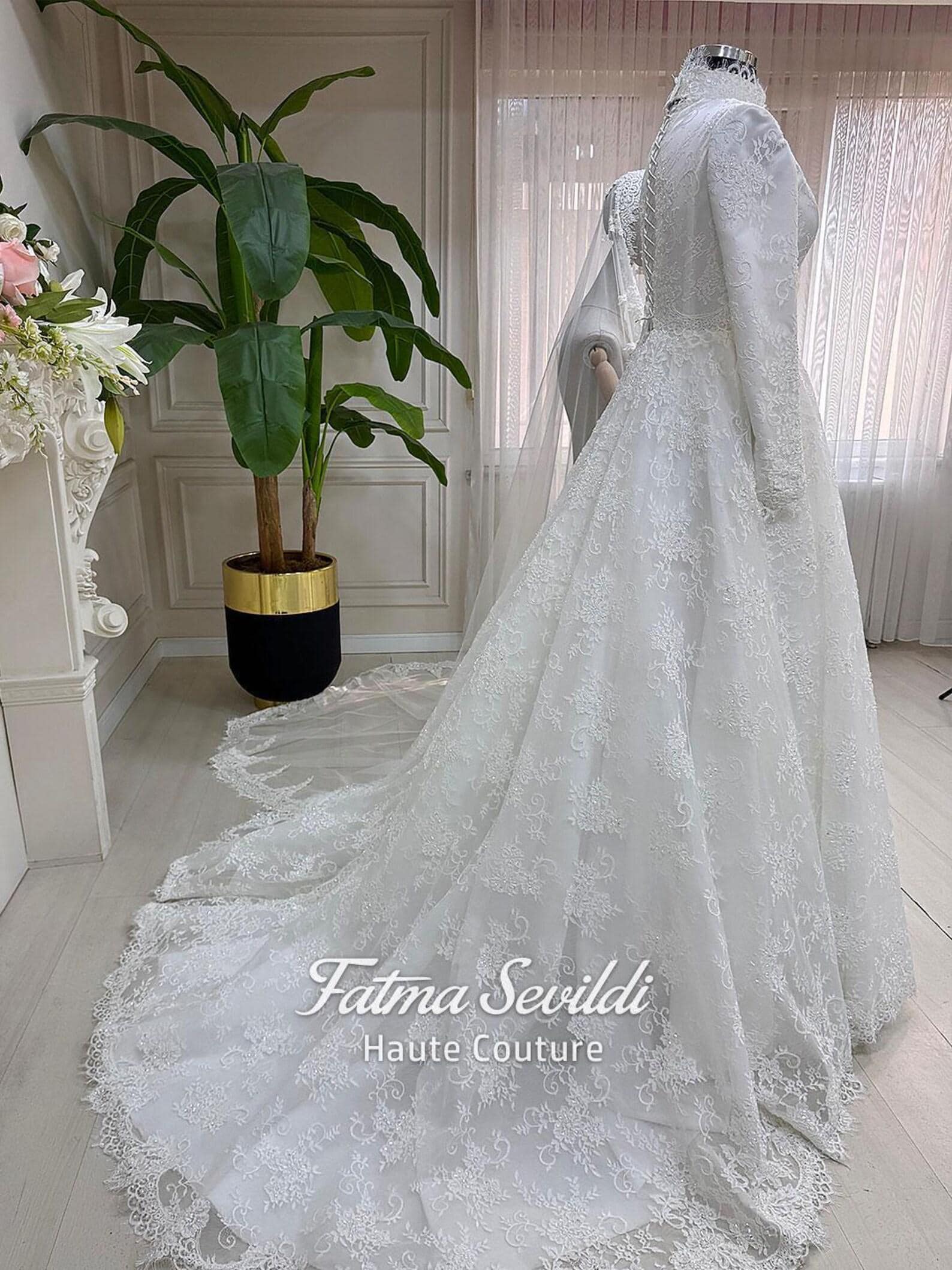Veiled hijab wedding dress with lace capelet, high neck, long sleeves, and couture beaded lace in a regal ball gown silhouette. Includes premium lace veil, headscarf, and petticoat.