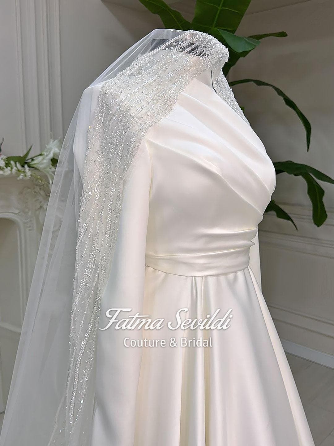 Hijab wedding dress in luminous satin with high neck and long sleeves, custom made in an elegant A-line silhouette for modest bridal coverage. Includes a free standard tulle veil (non-lace).
