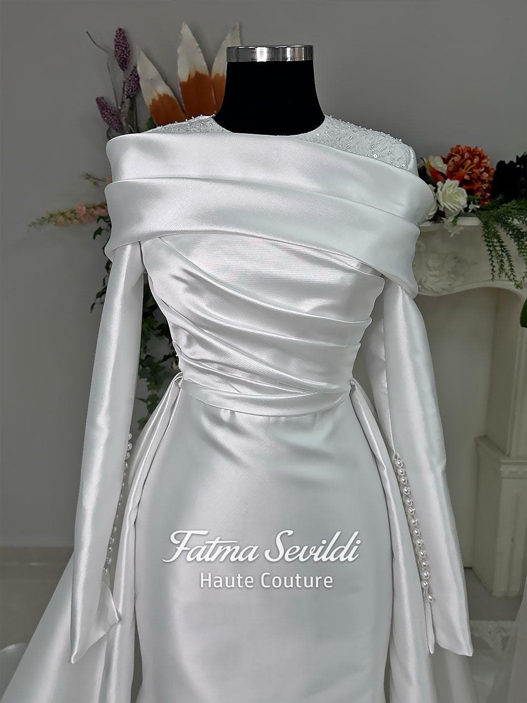 Luxury satin hijab wedding dress with off-shoulder long sleeves and an A-line silhouette, shown with premium lace veil and dramatic train. Custom couture modest bridal gown design with elegant draping and pearl details.