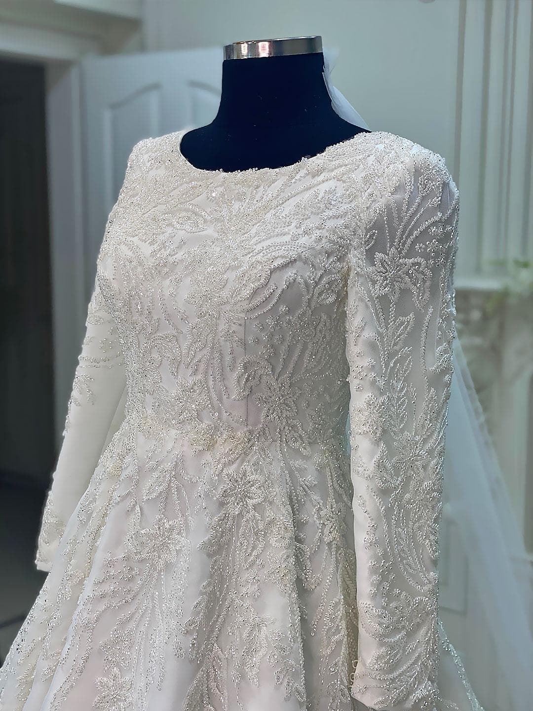 Luxury veiled hijab wedding dress with beaded lace, long sleeves, full coverage bodice, and elegant A-line bridal silhouette. Modest Muslim wedding gown with custom couture detailing and romantic lace veil.