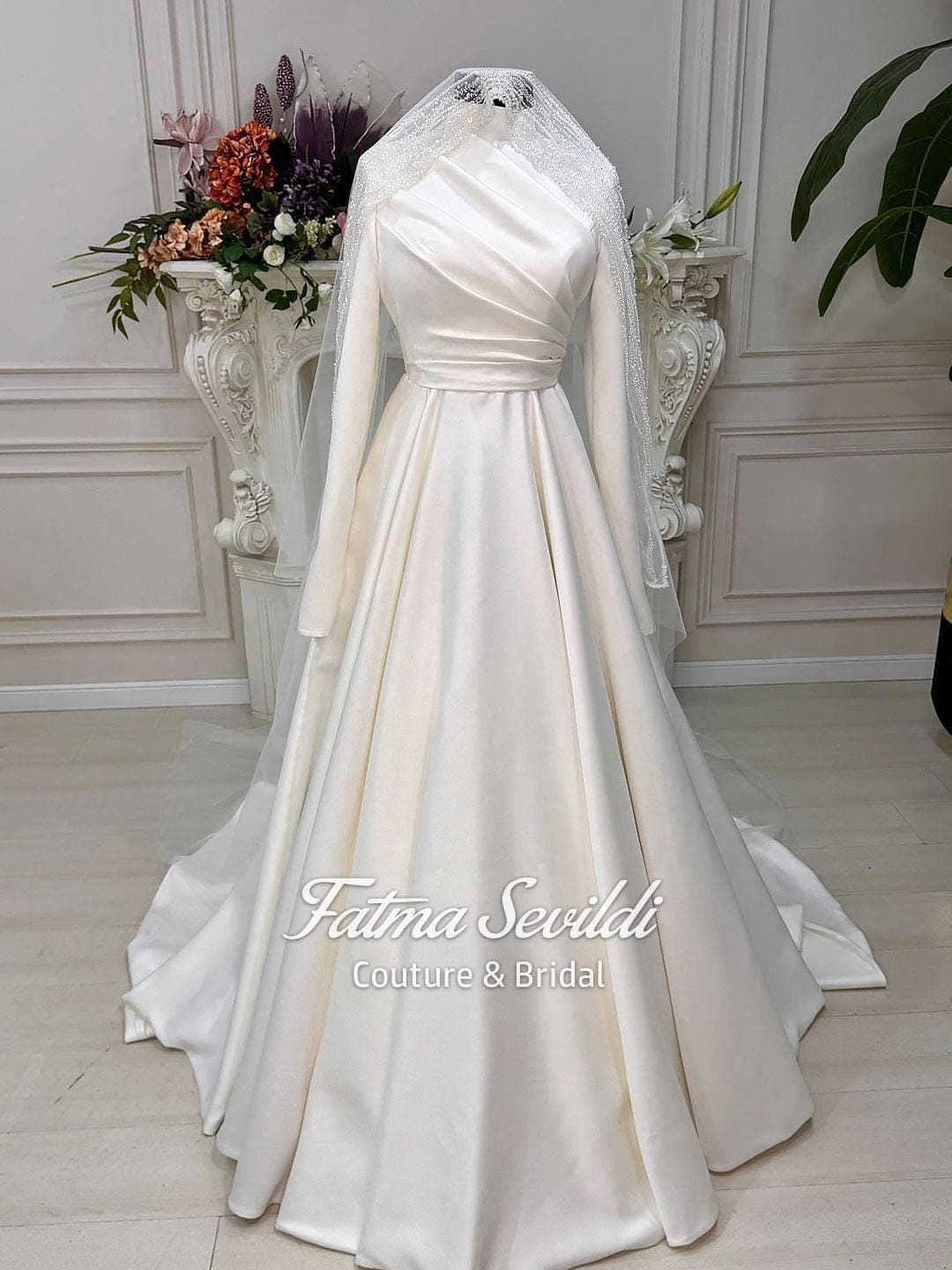 Hijab wedding dress in luminous satin with high neck and long sleeves, custom made in an elegant A-line silhouette for modest bridal coverage. Includes a free standard tulle veil (non-lace).