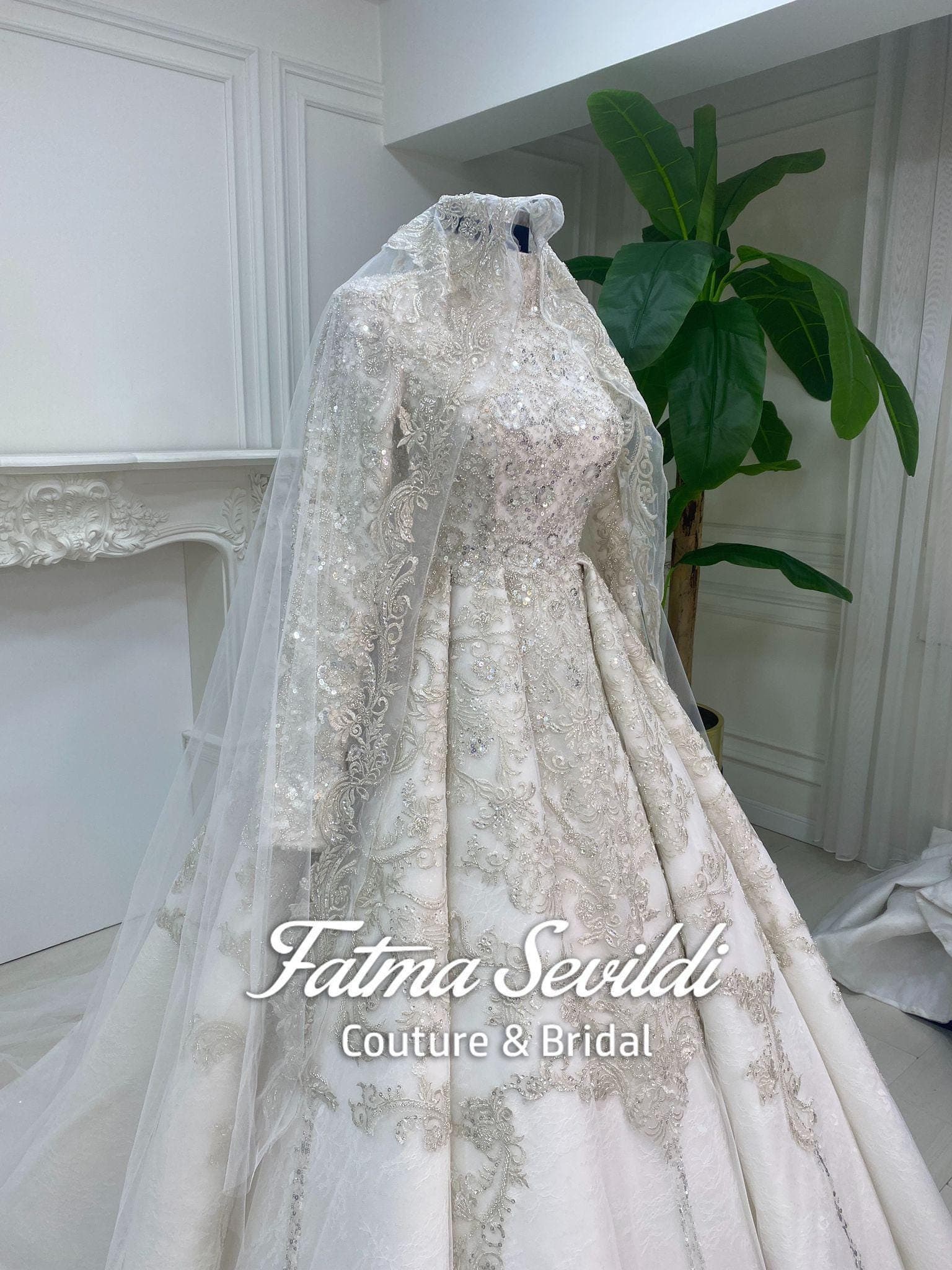 Veiled hijab wedding dress with high neck and long sleeves, featuring shimmering beaded lace and a lace-edge veil included.