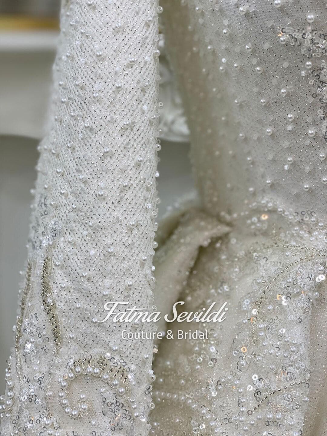 Veiled hijab wedding dress in a modest ballgown silhouette with high neck, long sleeves, and hand-beaded lace sparkle, including a premium lace veil.