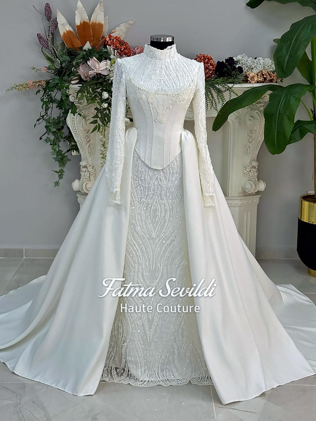 Luxury hijab wedding dress with long sleeves, high neck, beaded lace mermaid silhouette and detachable overskirt, veiled bridal set. Handmade couture modest bridal gown with lace-up corset back and sparkling embroidery.