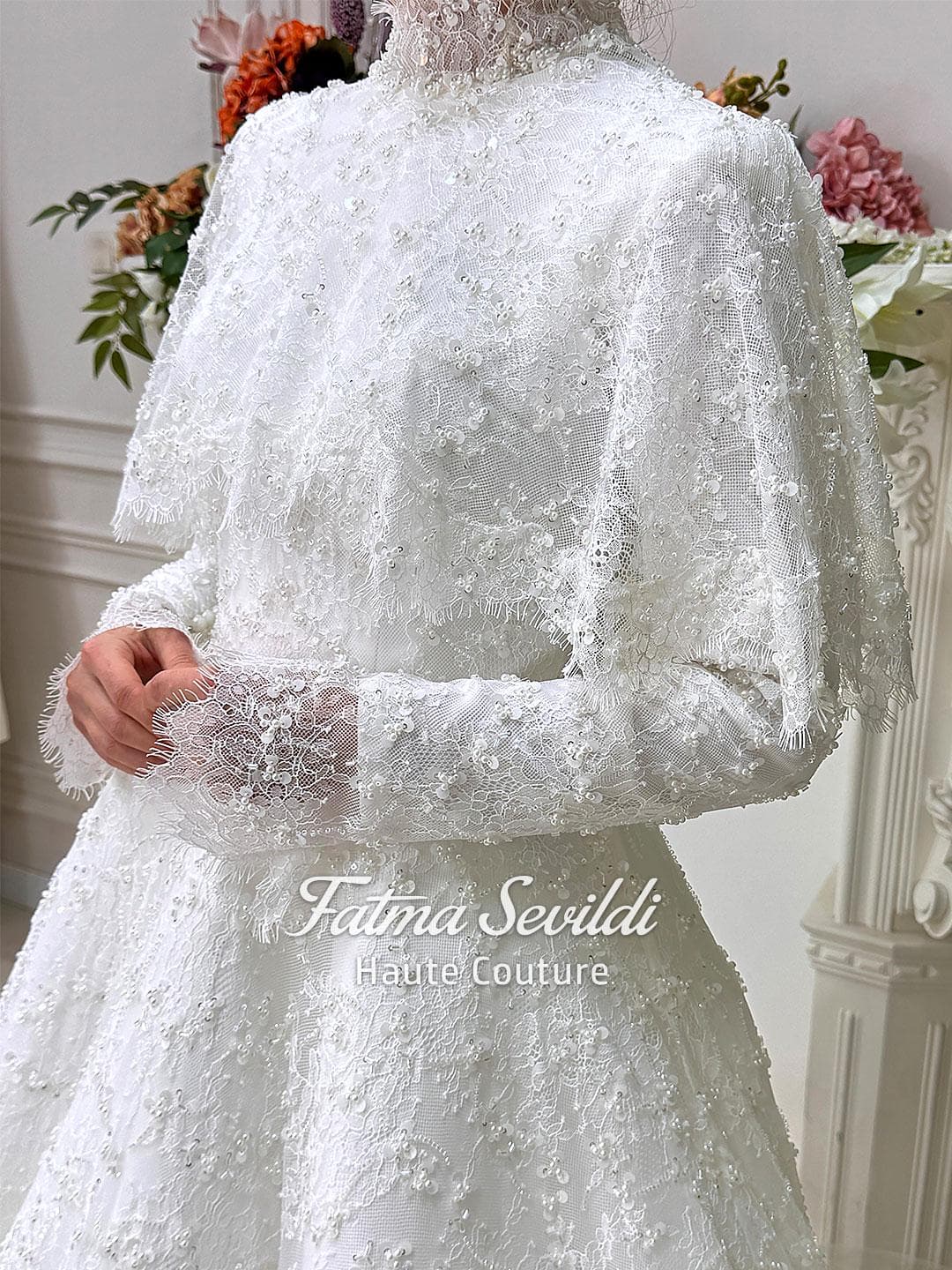 Veiled hijab wedding dress with high neck, long sleeves, and shimmering beaded lace in an elegant A-line silhouette. Includes premium lace veil, headscarf, and a lace short cape for a complete modest bridal set.