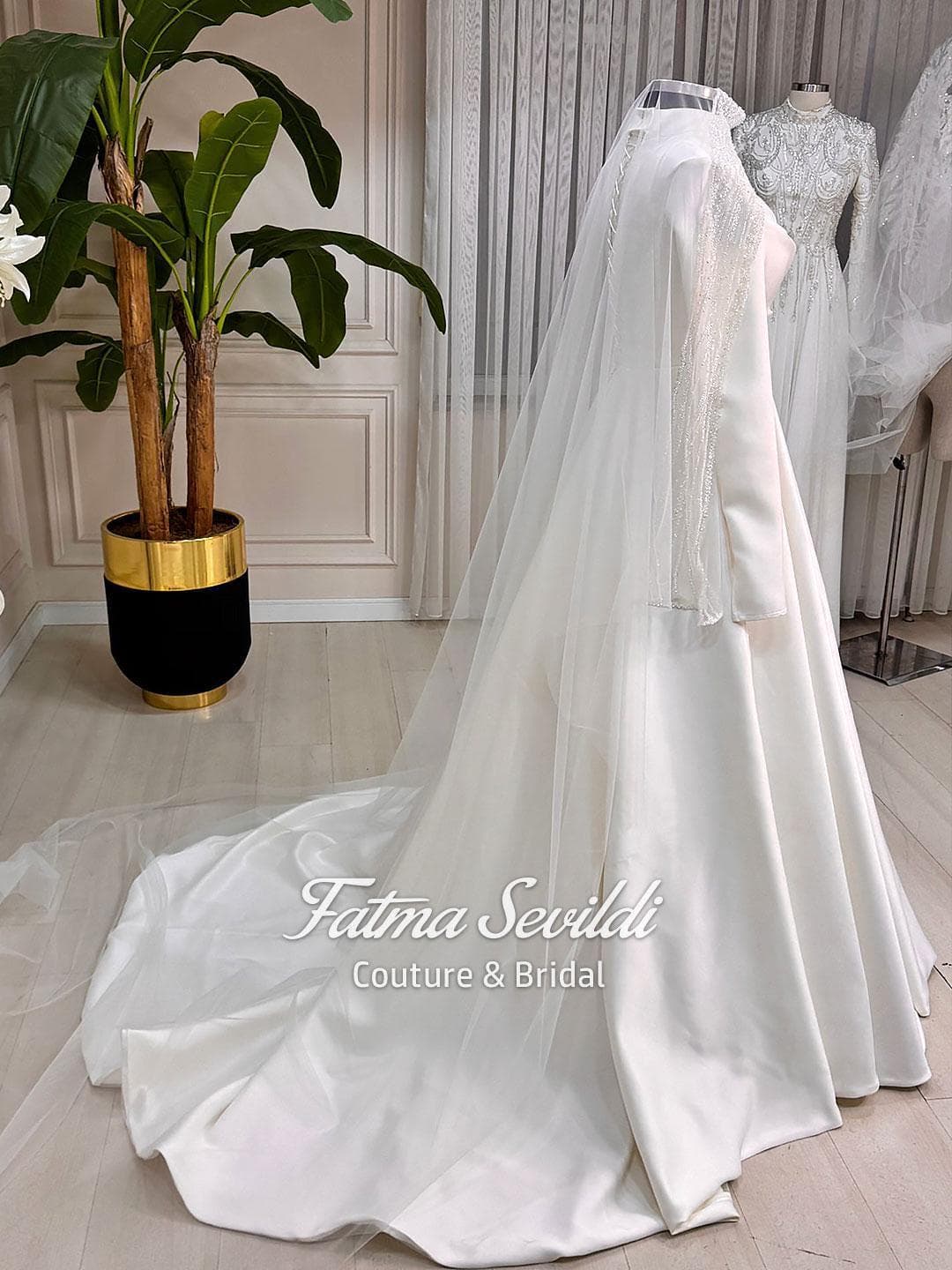 Hijab wedding dress in luminous satin with high neck and long sleeves, custom made in an elegant A-line silhouette for modest bridal coverage. Includes a free standard tulle veil (non-lace).
