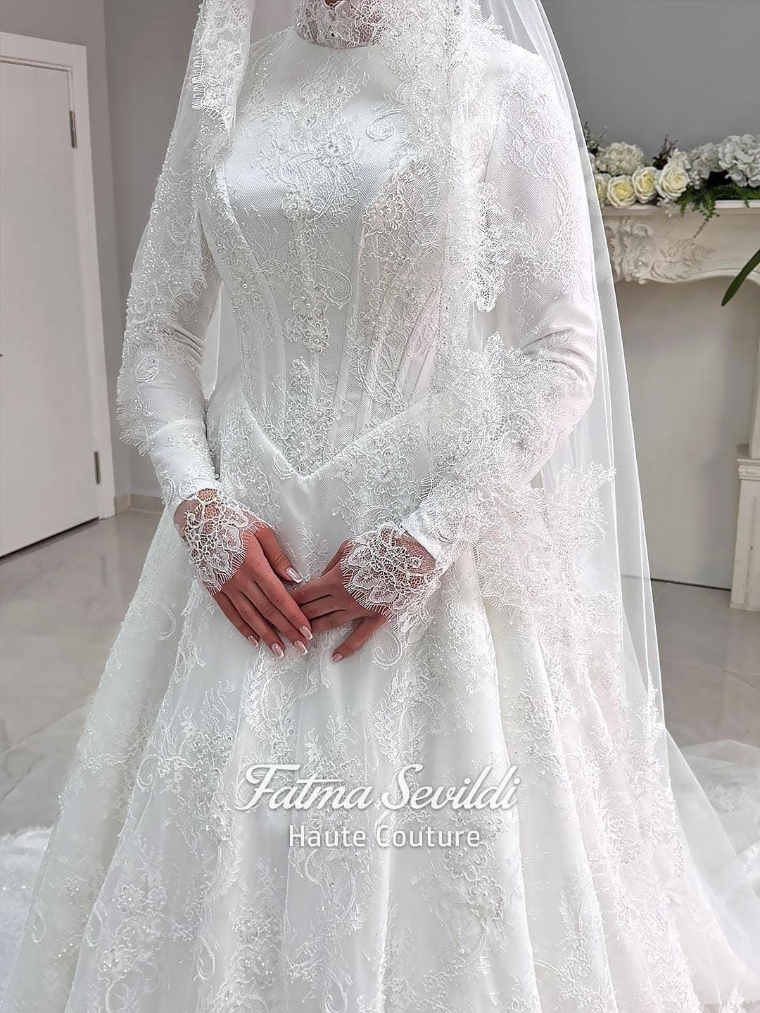 Luxury veiled hijab wedding dress with high neck, long sleeves, and beaded lace over a full A-line ball skirt. Premium lace veil included for a complete modest bridal set.