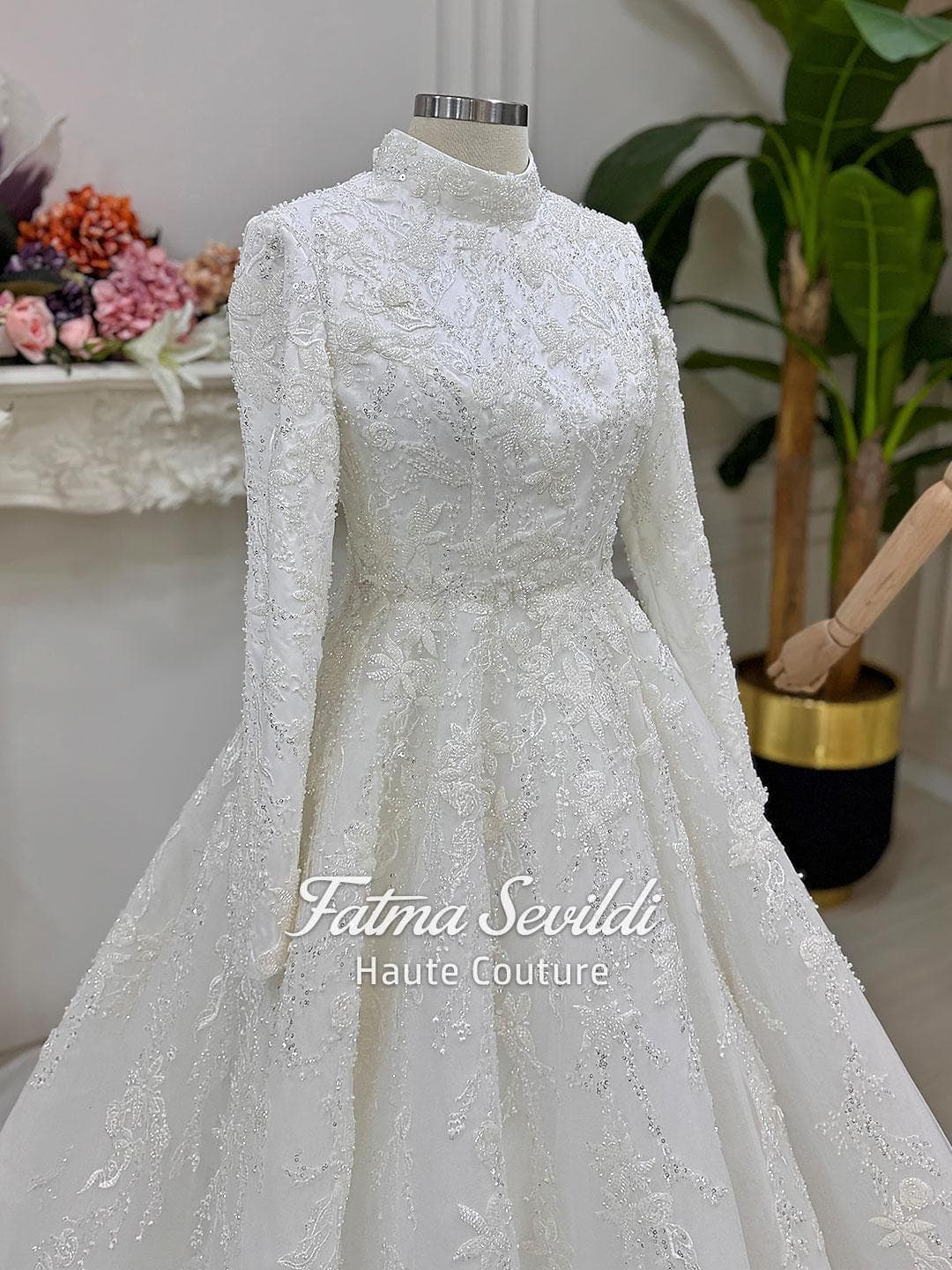 Veiled hijab wedding dress with high neck, long sleeves, and shimmering beaded lace in a couture ballgown silhouette. Includes headscarf, petticoat, and a premium lace veil.