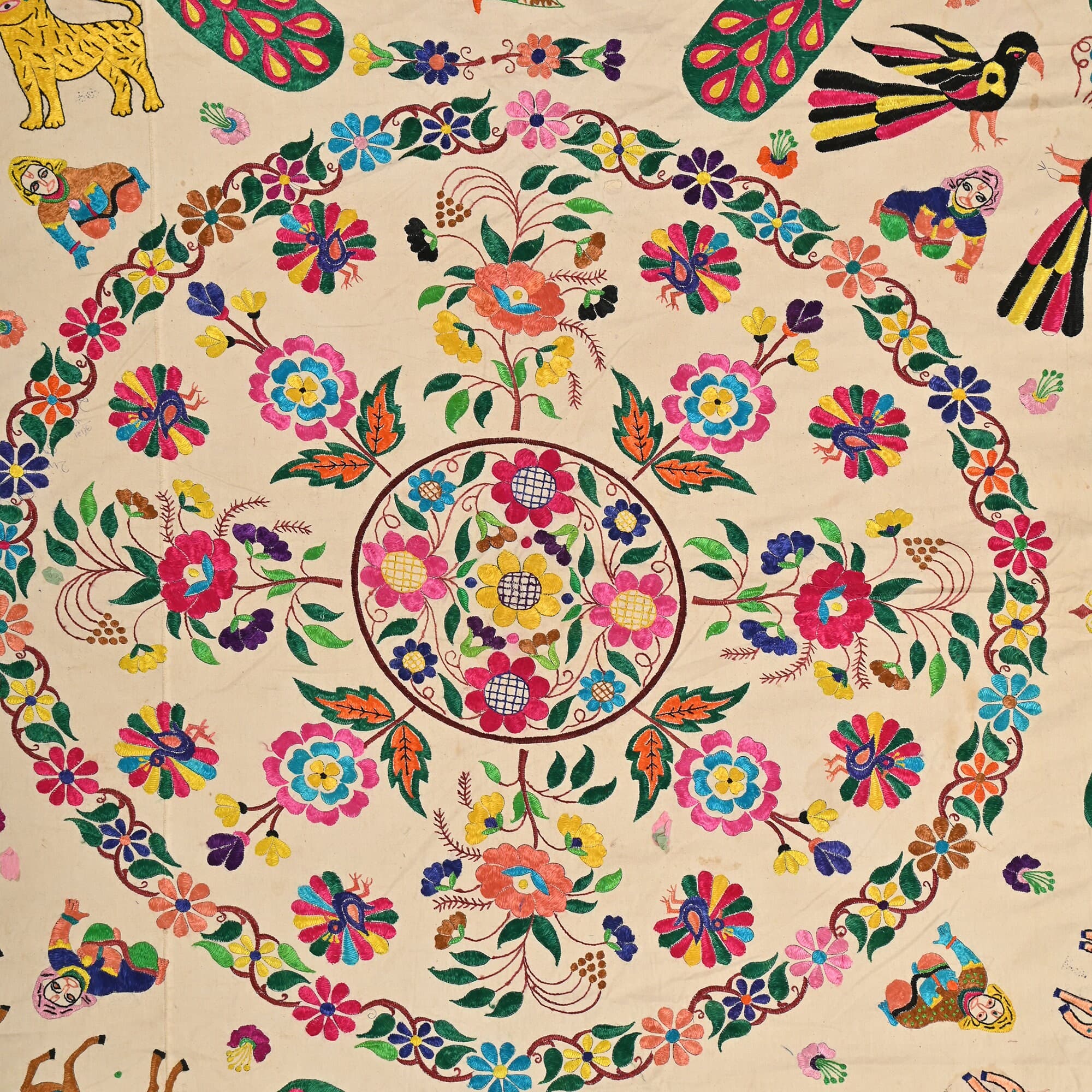 May include: Vintage Tribal Tapestry white fabric with colorful embroidery of flowers, leaves, and birds. The center of the fabric has a large circular design with a smaller circular design inside. The outer edge of the fabric has a border of smaller circular designs.