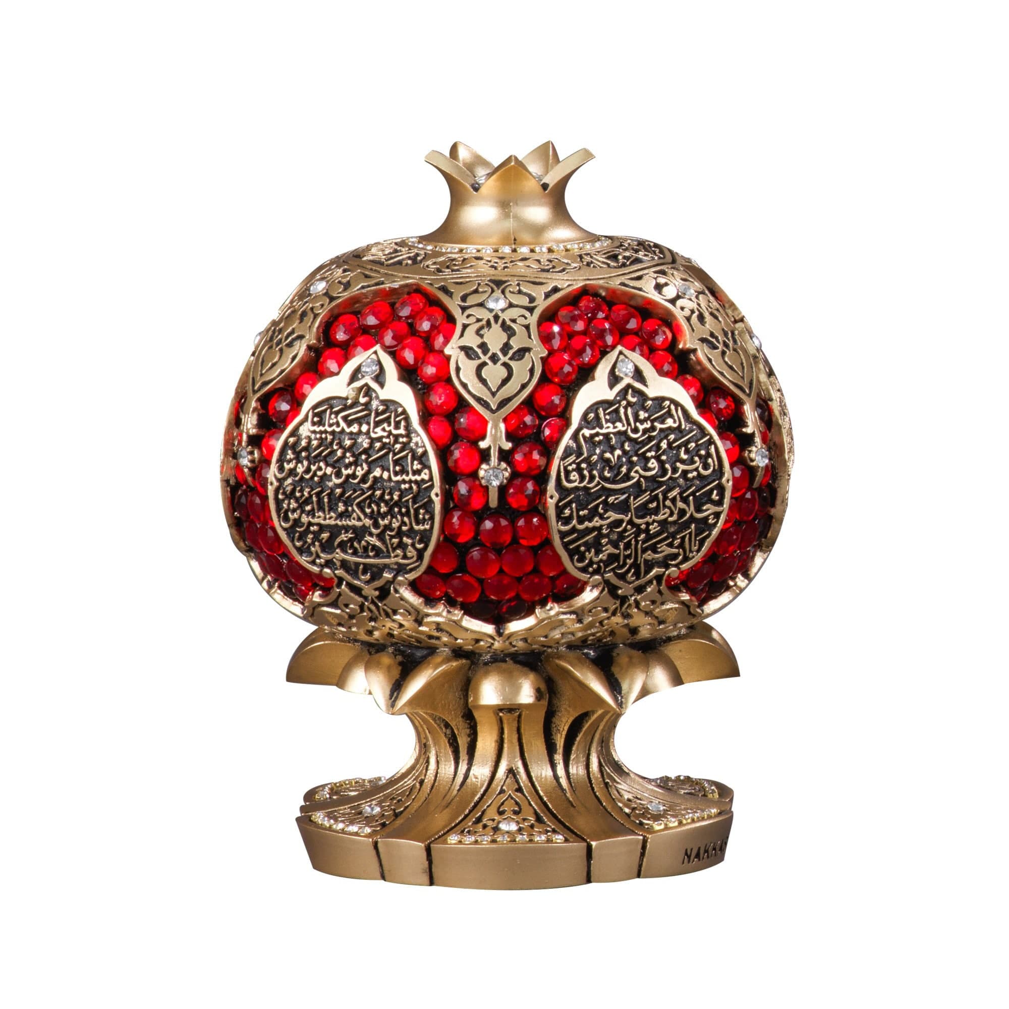 A gold and red decorative pomegranate with intricate details and red jewels. The pomegranate is on a gold stand with the word 'NAKA' at the base.