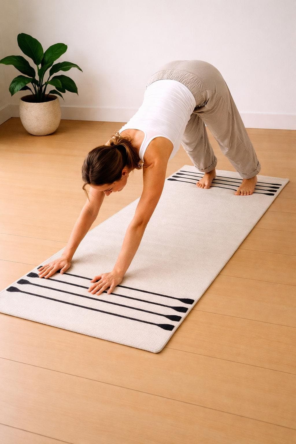 Female practicing yoga on cream organic cotton mat, 24x72 handmade non toxic minimalist yoga rug for home use