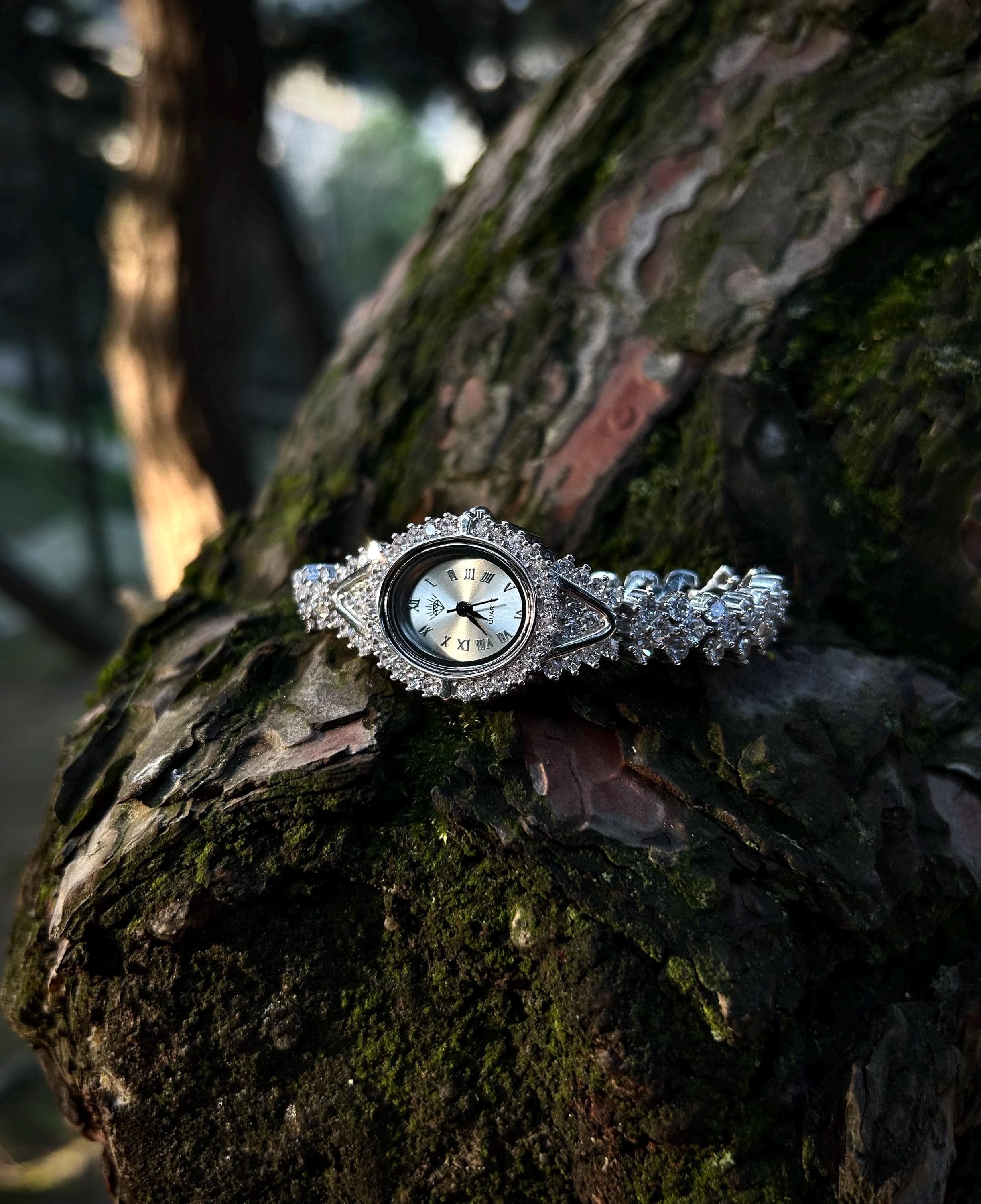 Elegant women’s watch with sparkling gemstone bracelet laid flat on display surface.