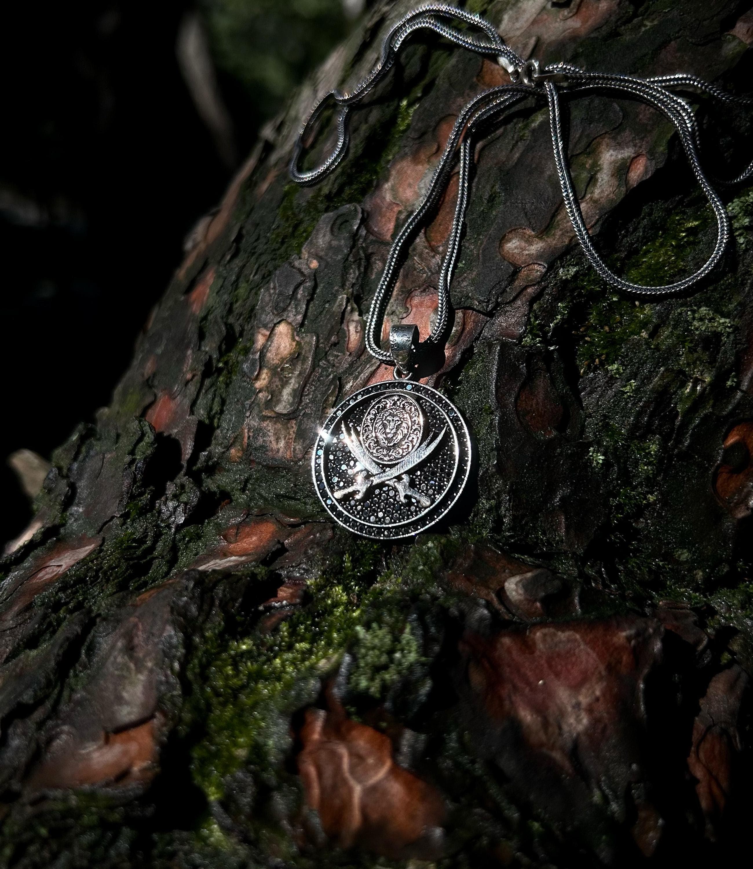 925 sterling silver necklace with Zulfikar sword and lion head motif, placed on a dark textured surface, reflecting Islamic warrior spirit and handcrafted detailing.