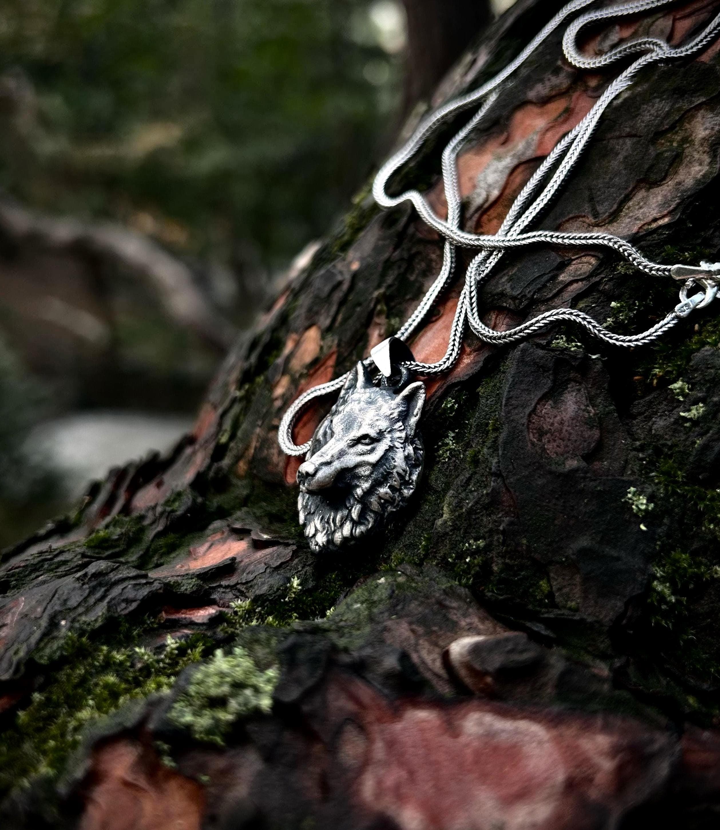 A high-quality 925 sterling silver wolf necklace for men, shown as a stylish accessory on a dark background.