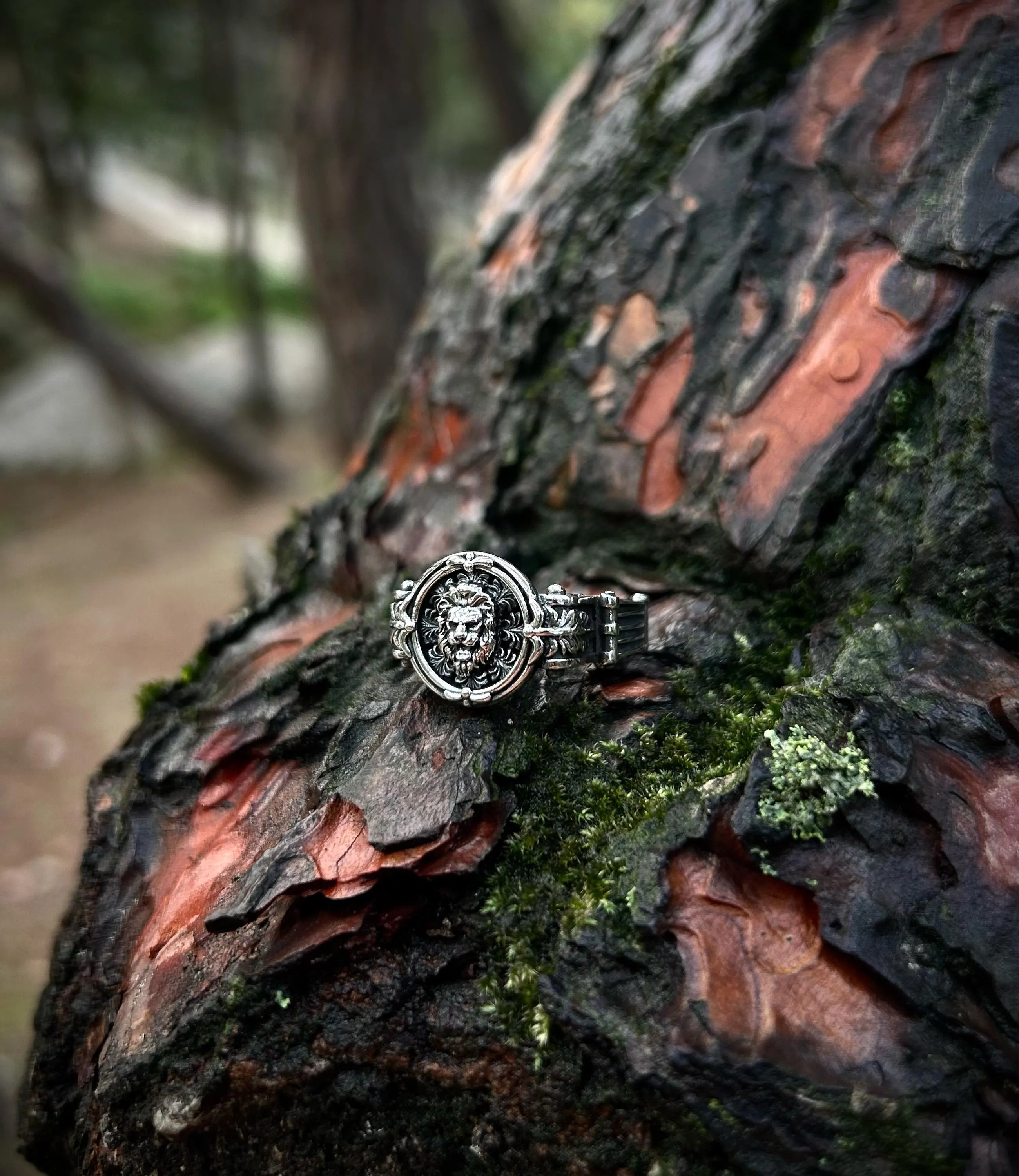A man's hand wearing a minimalist 925 sterling silver lion signet ring, showcasing its subtle and stoic design as an everyday accessory.