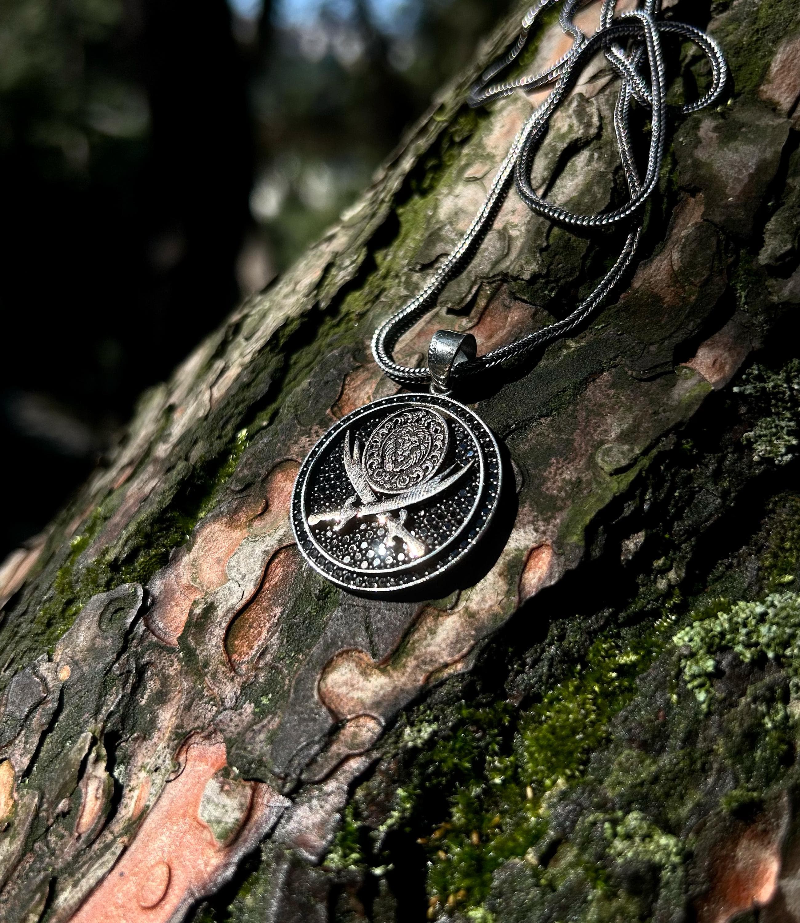 925 sterling silver necklace with Zulfikar sword and lion head motif, placed on a dark textured surface, reflecting Islamic warrior spirit and handcrafted detailing.
