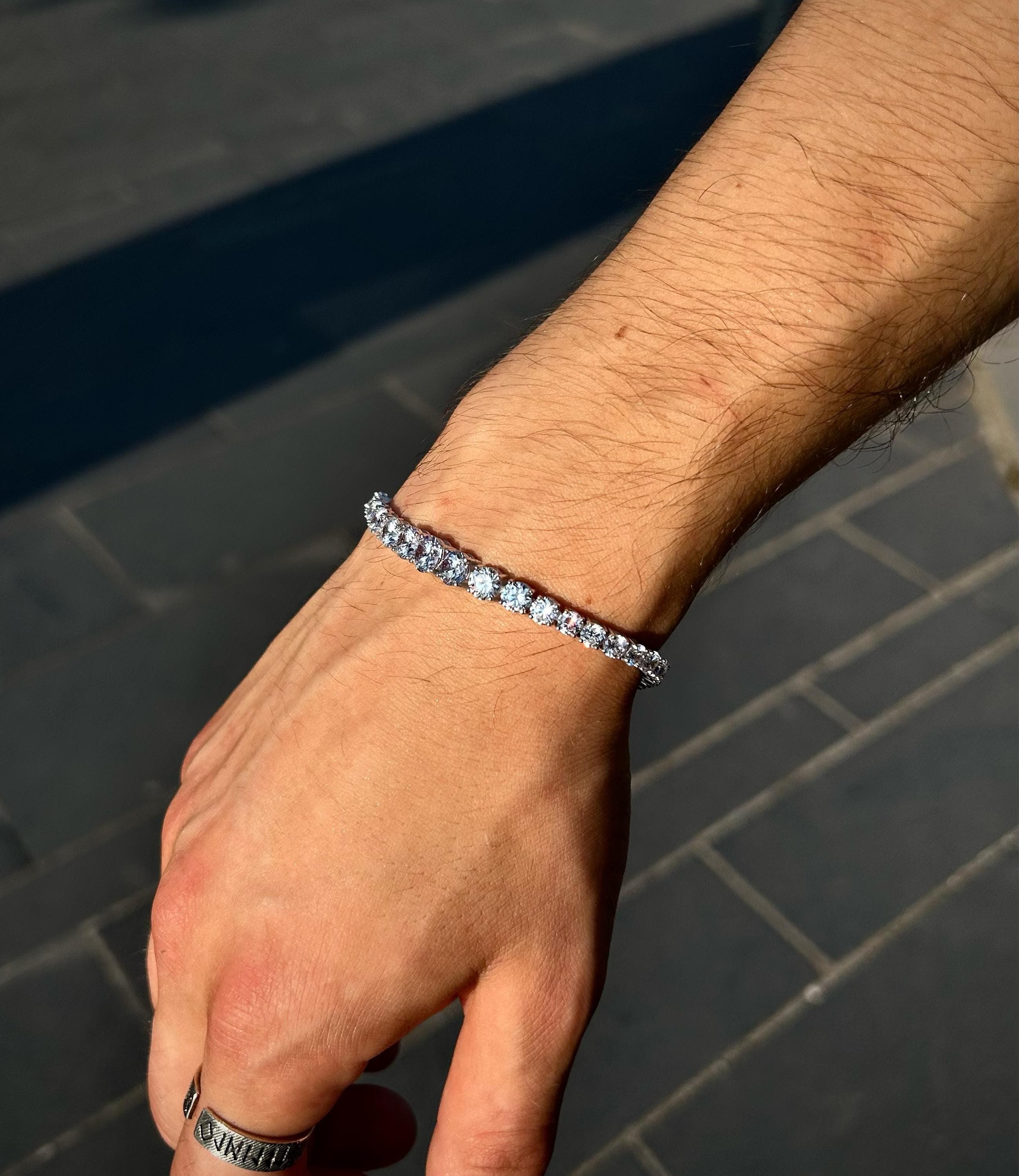 925 sterling silver tennis bracelet featuring gradually increasing CZ stones, laid on a soft neutral background to highlight its handmade sparkle and elegant design.