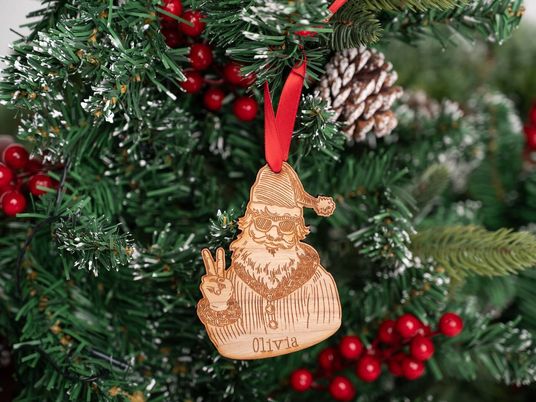 Santa holding his fingers up in the peace symbol - wooden bauble with the name olivia engravedon