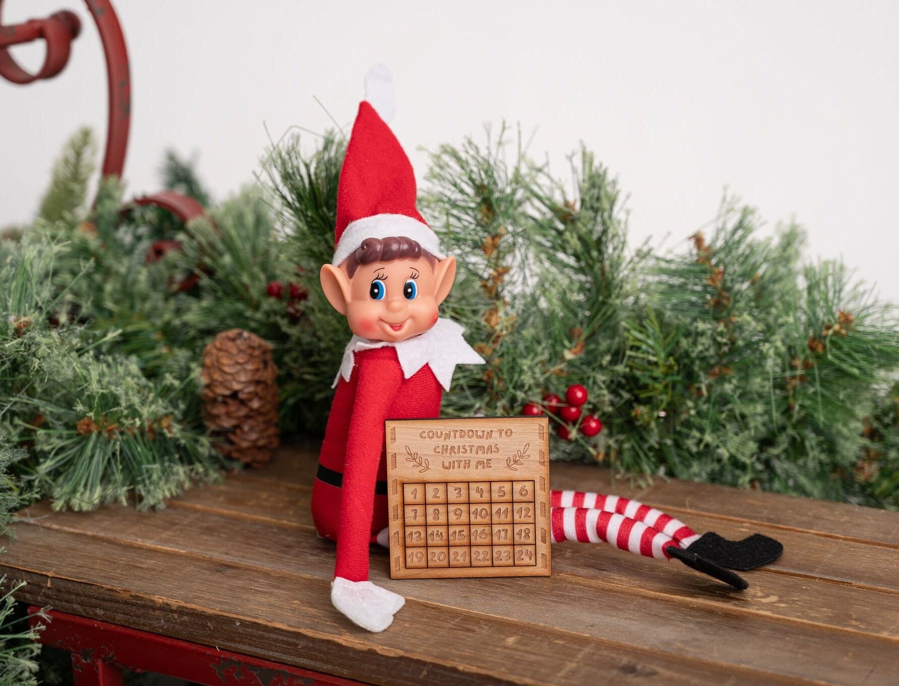 Elf sat with a wooden countdown calendar prop