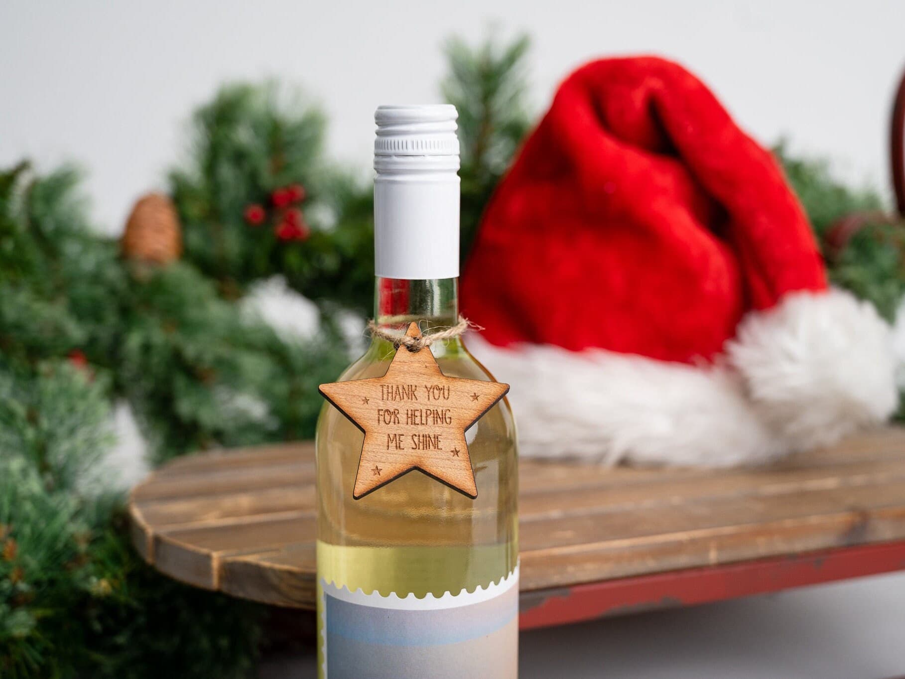 Wooden star shaped gift tag tied around the neck of a wine glass