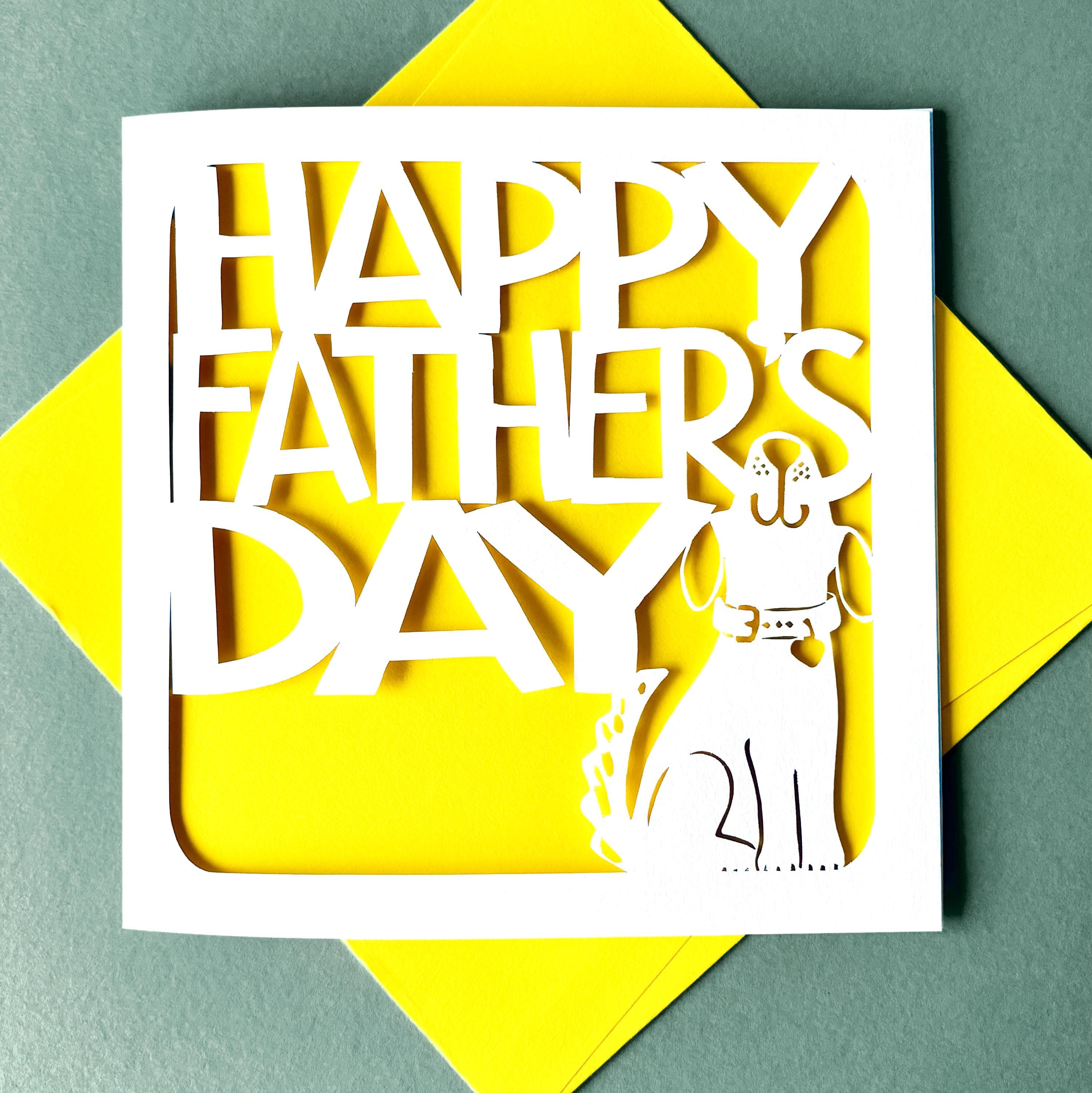 White square laser cut Father's Day card. Featuring a cute dog outline, looking up and wagging his tail. Behind the words 'Happy Father's Day' are cut in a bold font. The card has a bright yellow paper insert and is lying on a colour-matched envelope. The card is lying against a dusty blue background.