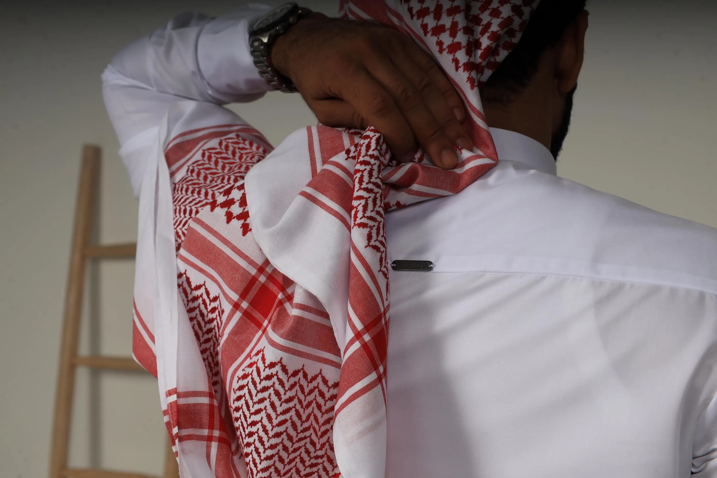 White Collar thobe with black buttons styled with a red and white keffiyeh scarf