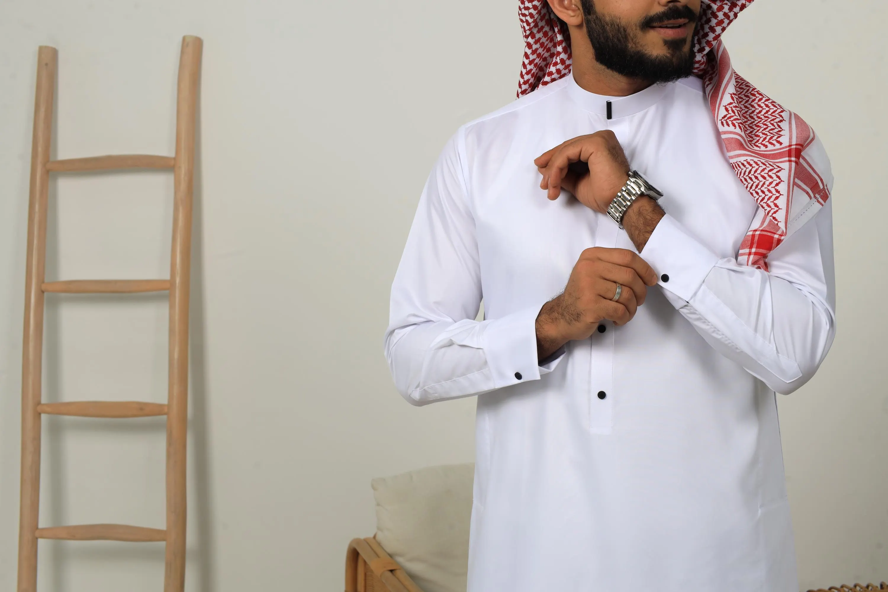 White Collar thobe with black buttons styled with a red and white keffiyeh scarf