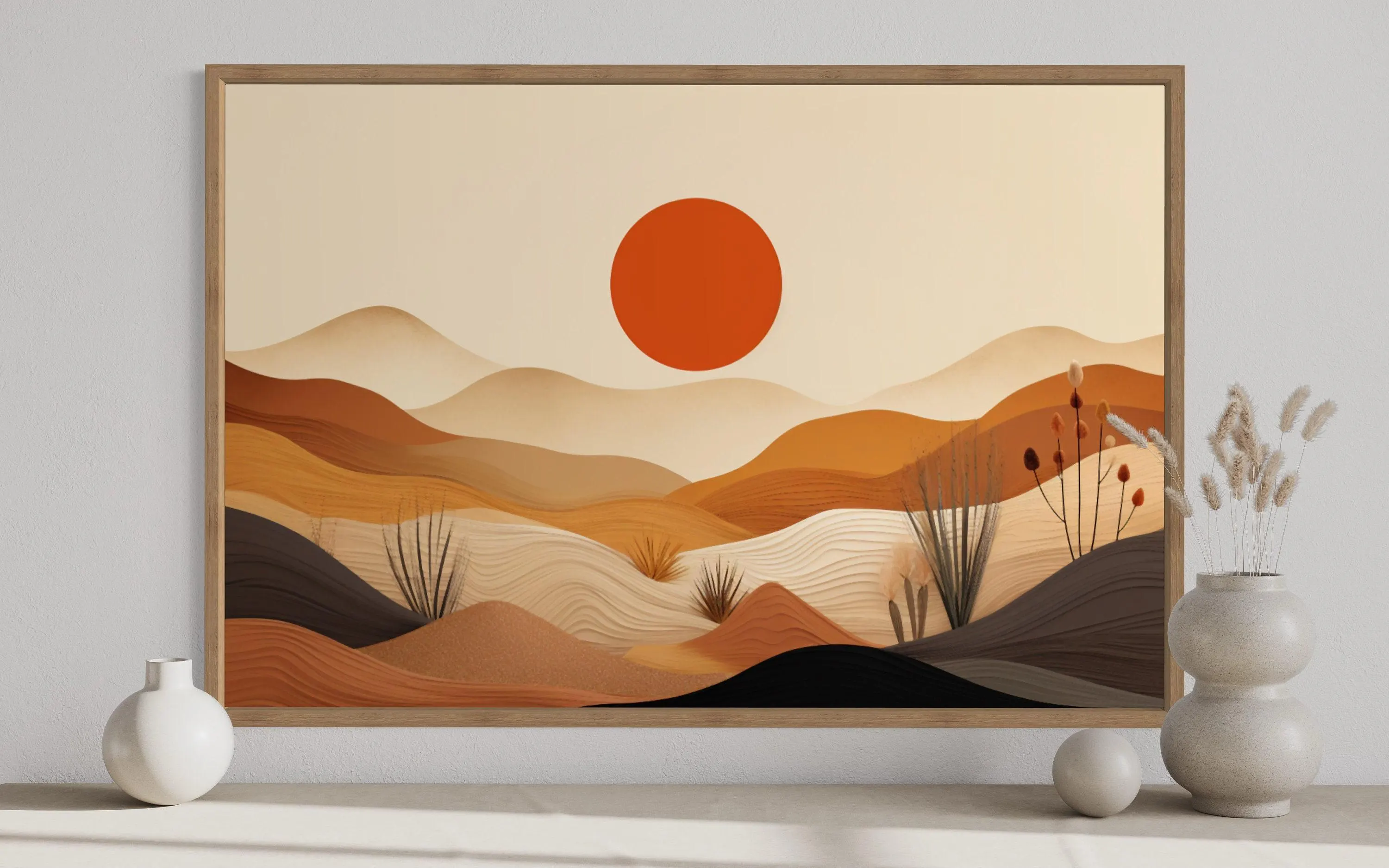 a large framed artwork depicting a desert landscape with mountains, a sun, and various desert plants.