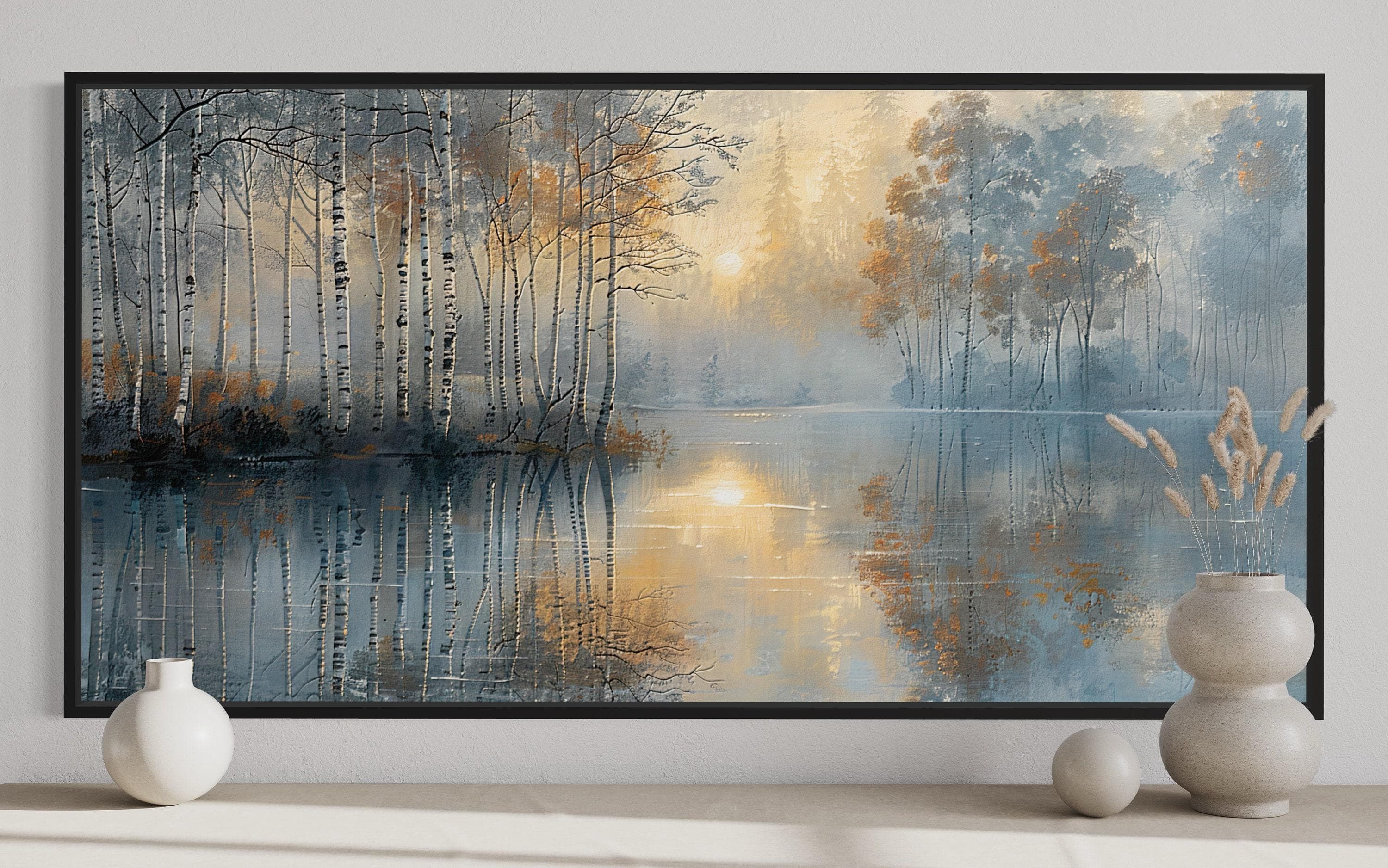 a serene landscape with a tranquil lake surrounded by a forest of birch trees. The trees have a mix of white and orange bark, and their reflections can be seen in the calm waters of the lake. The scene is framed by a black border, and there are two white vases and a small white sculpture placed on a shelf in the foreground.