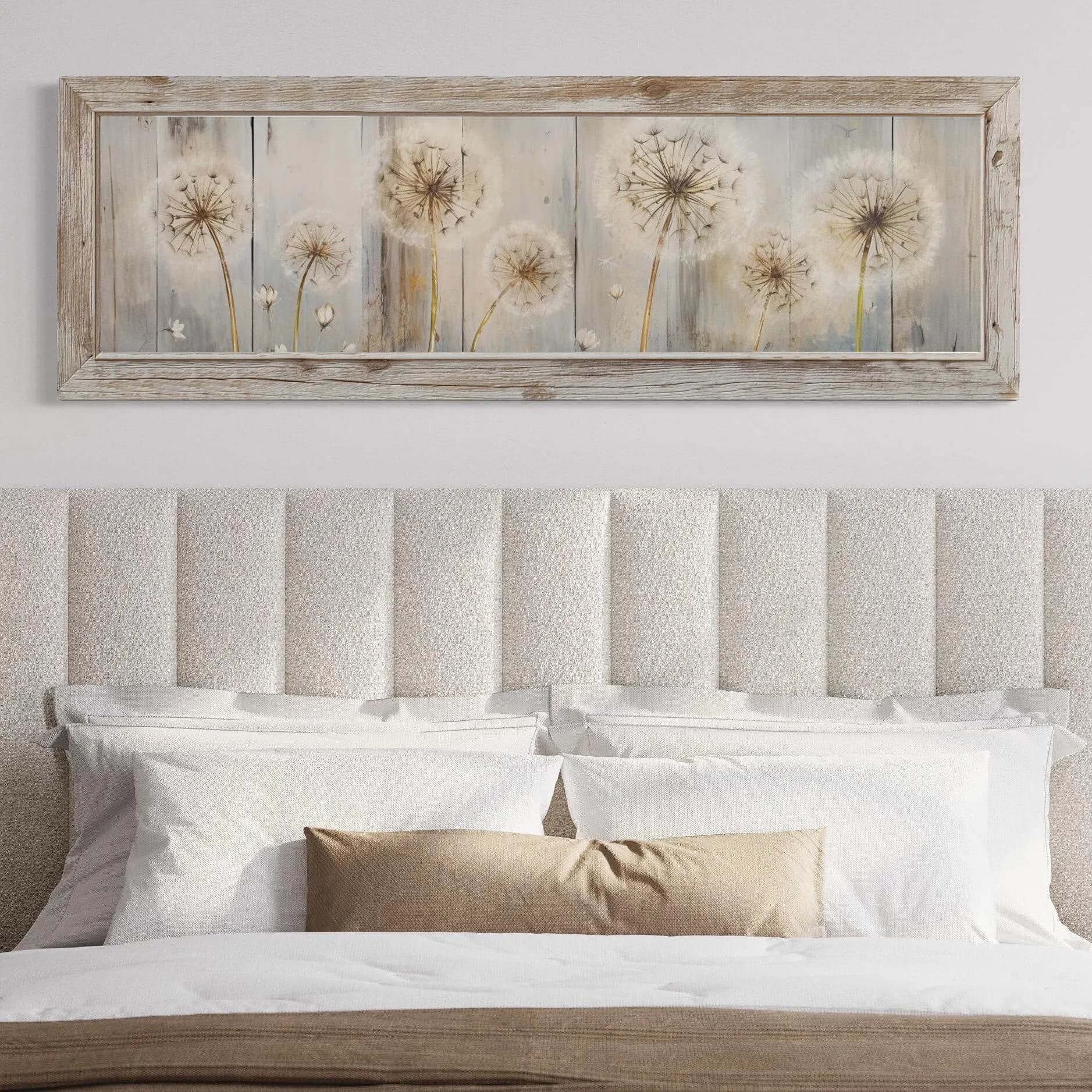 a bedroom setting with a bed and a framed artwork of dandelions on the wall above it.