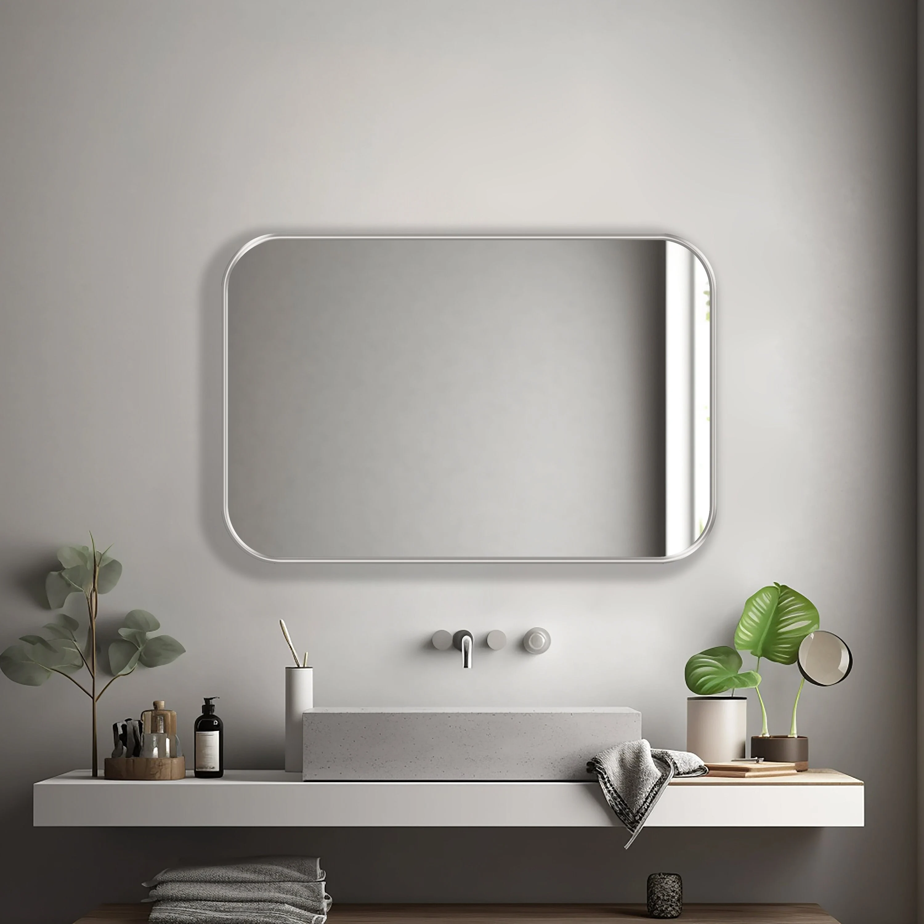 Rectangle mirror with silver frame hung on the wall of a bathroom.