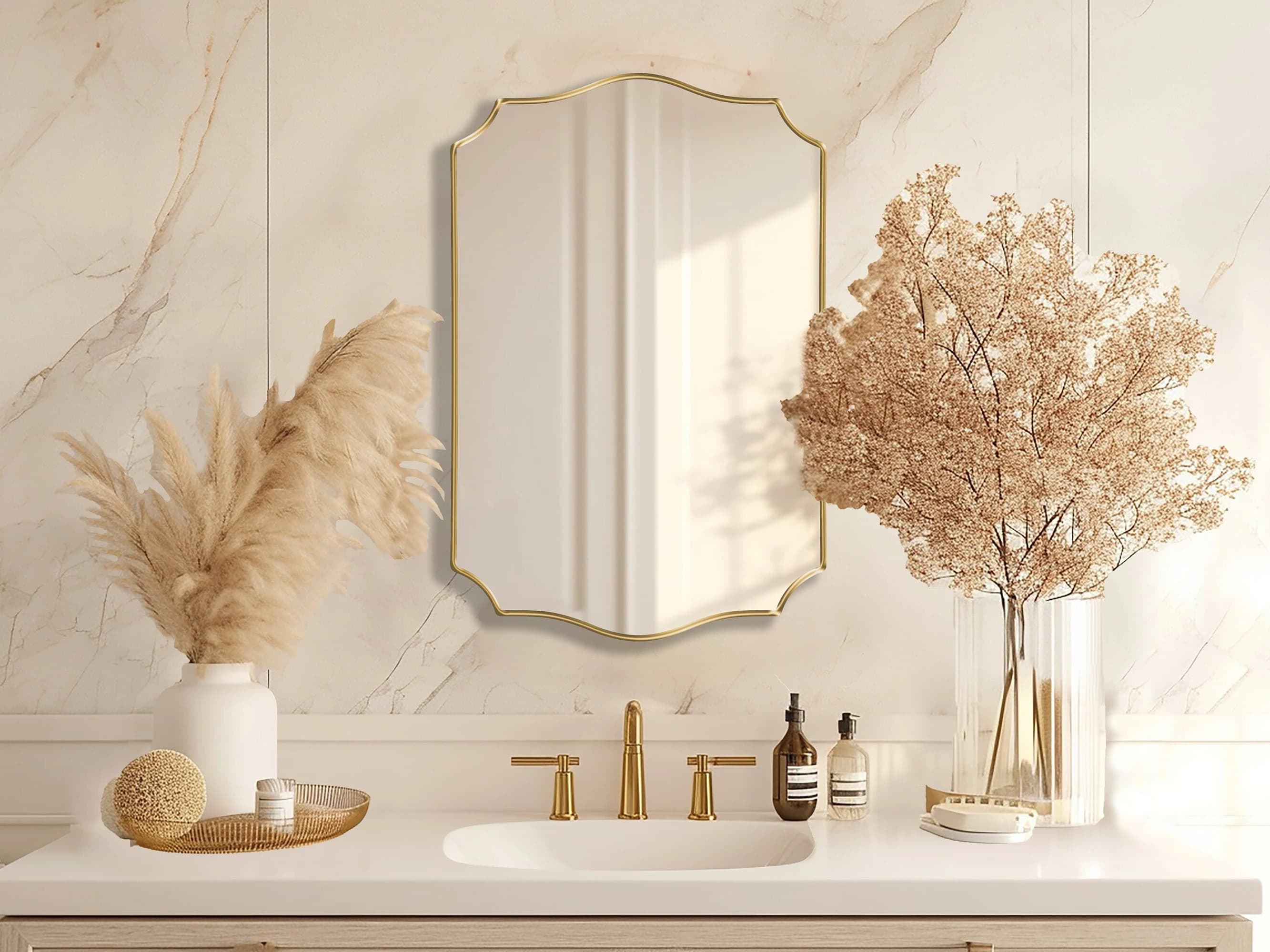 Pacifica Wave Mirror with gold frame hung on the wall of a bathroom over a vanity.