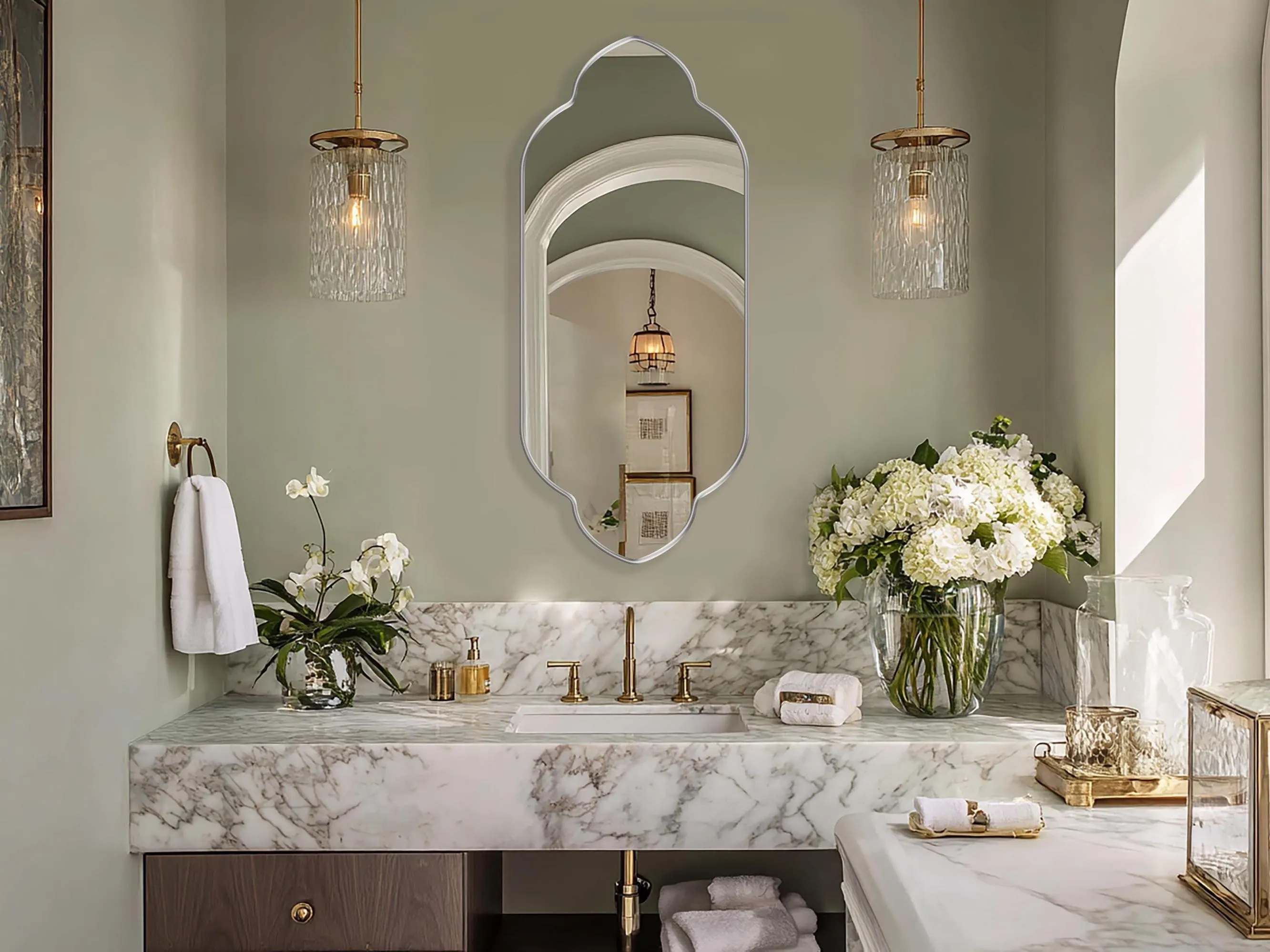 Zafira Mirror with silver frame finish hung on the wall of a powder room over a vanity.